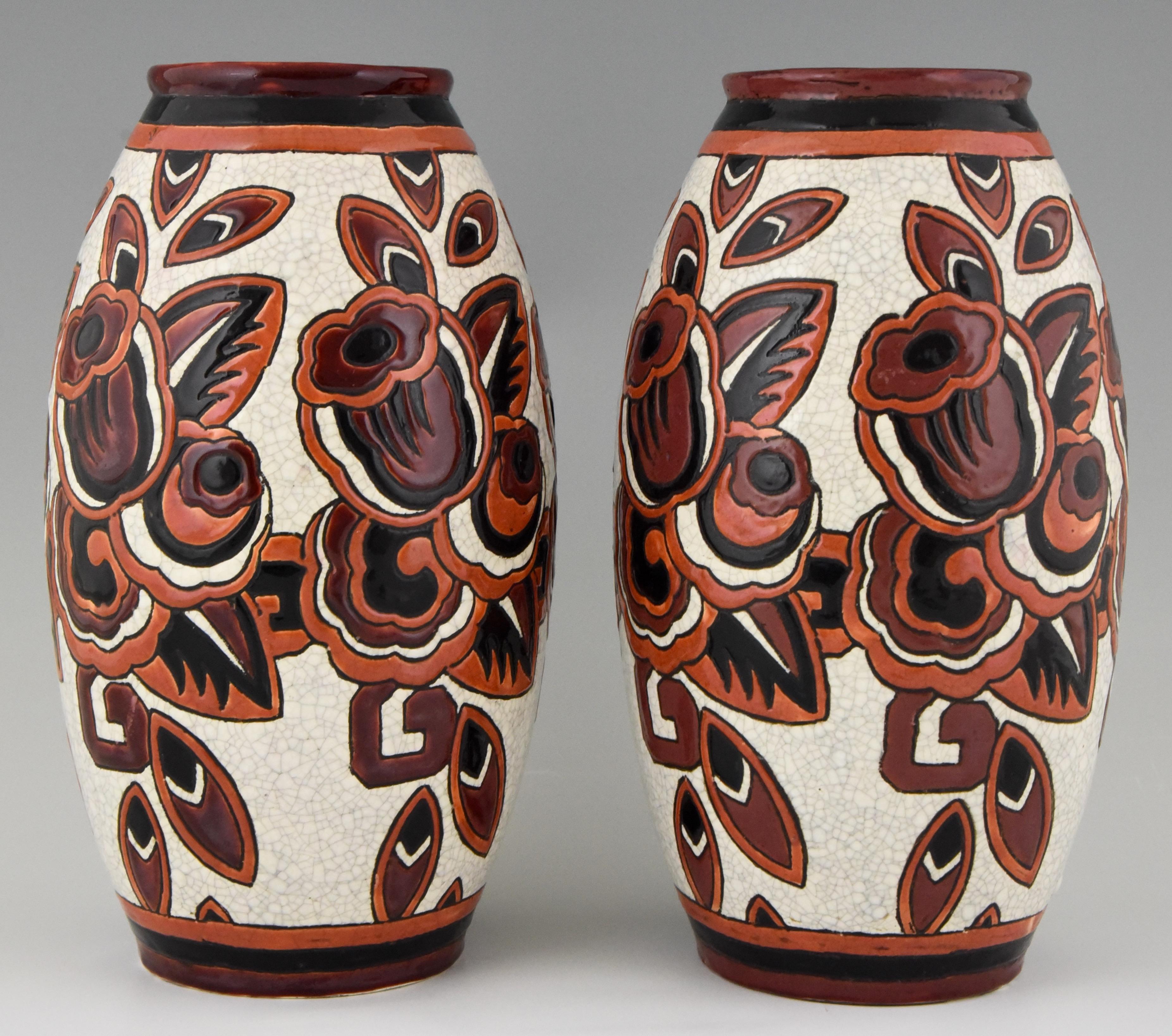 Lovely pair of Art Deco craquelé vases with flowers in the colors orange, black, brown and white. Designed in Belgium in 1926-1927 by Charles Catteau for Boch Frères. Both vases are stamped and numbered.