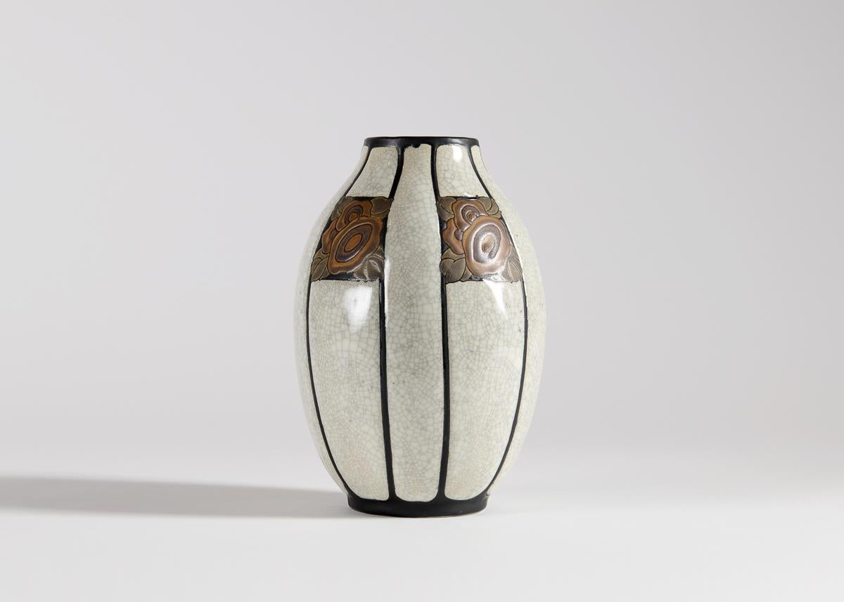 This vase has the decoration number D.767, dating it to 1923. The white craquelure glaze, surrounded by black stripes, is typical of Catteau's Art Deco designs for Keramis.

Bibliography:
For illustrations of a similar vase, see:
- Marc Pairon, Art
