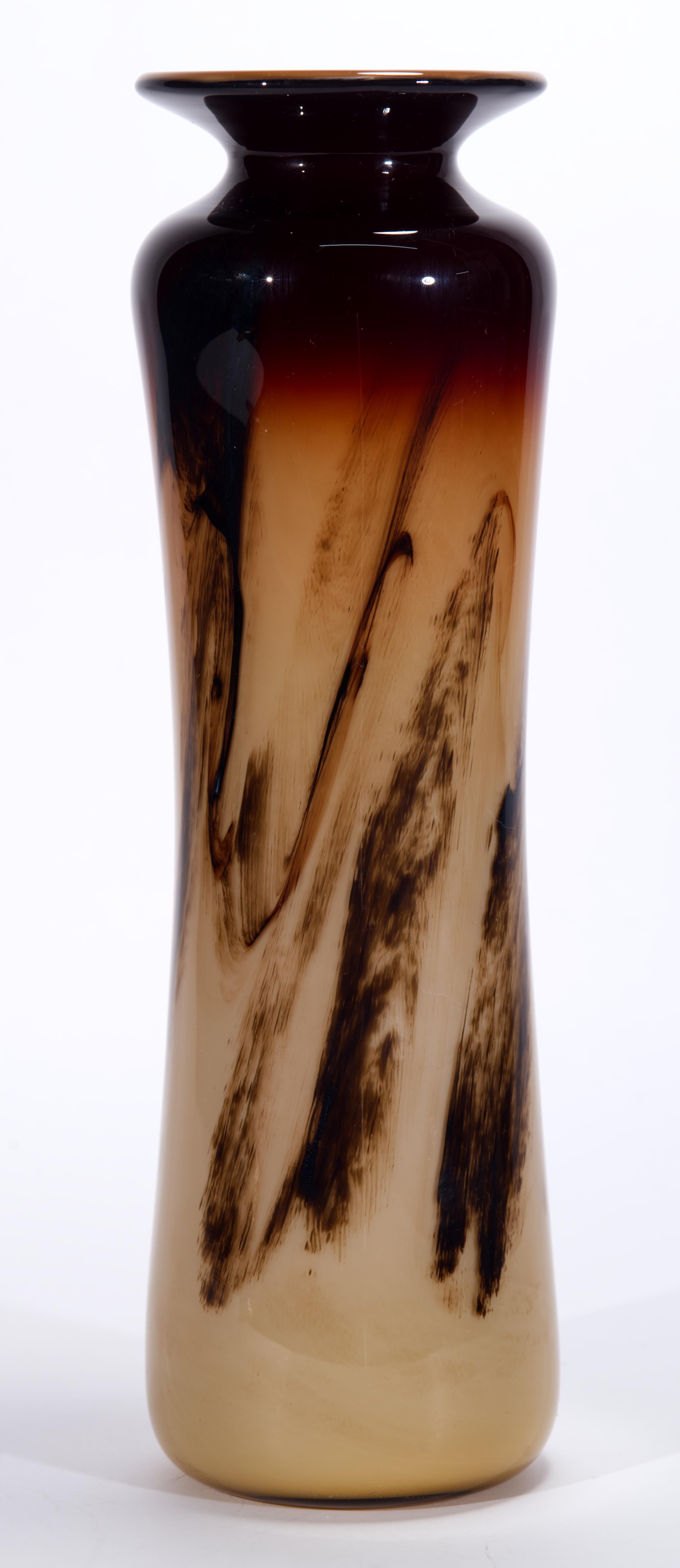  Il vaso scultoreo vintage soffiato a mano presenta un effetto ombreggiato sul corpo allungato, con un rosso bordeaux intenso sul bordo che sfuma in marrone moka alla base grazie ai motivi astratti di vetro fuso. Il vetro colorato è racchiuso in uno