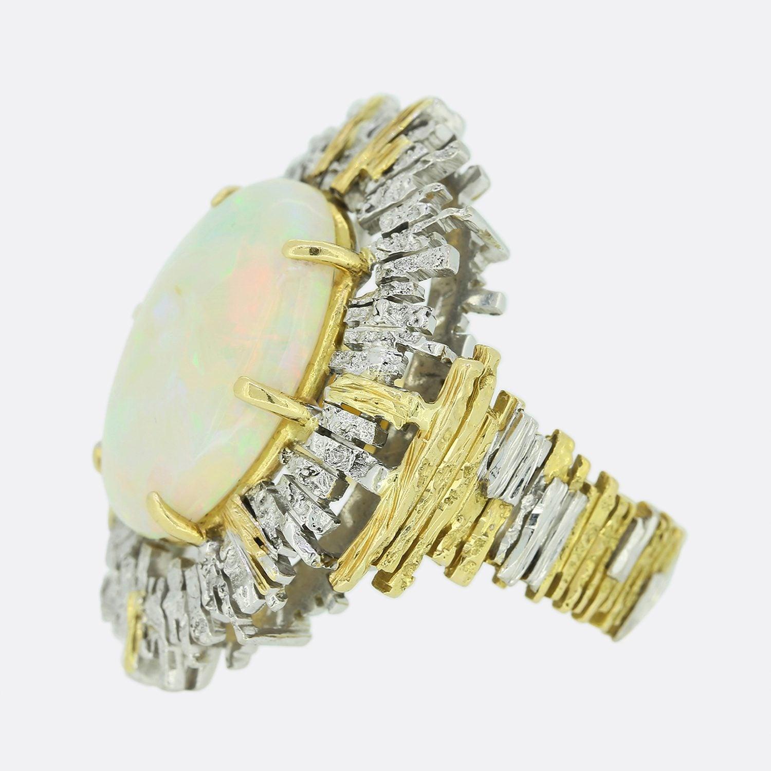 This is an 18ct yellow gold ring from the luxury jewellery designer Charles De Temple. The ring features a large oval cabochon opal which has been claw set in an 18ct yellow and white gold abstract setting. 

Charles de Temple was an American