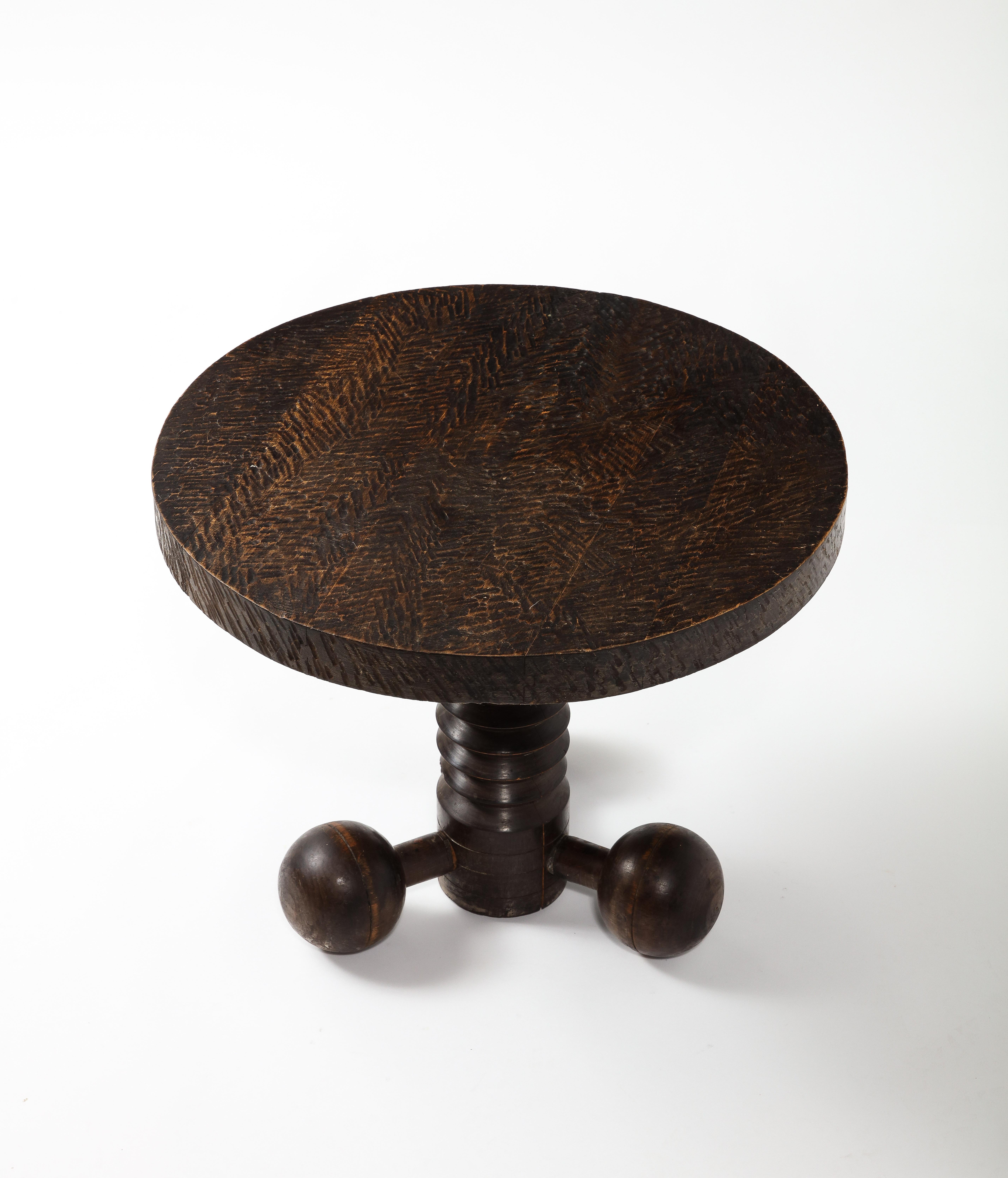 Finely carved and incised end table by Charles Douduyt, made of solid oak the incised top rest on a grooved column base supported by three detached spheres. An iconic form by this designer.