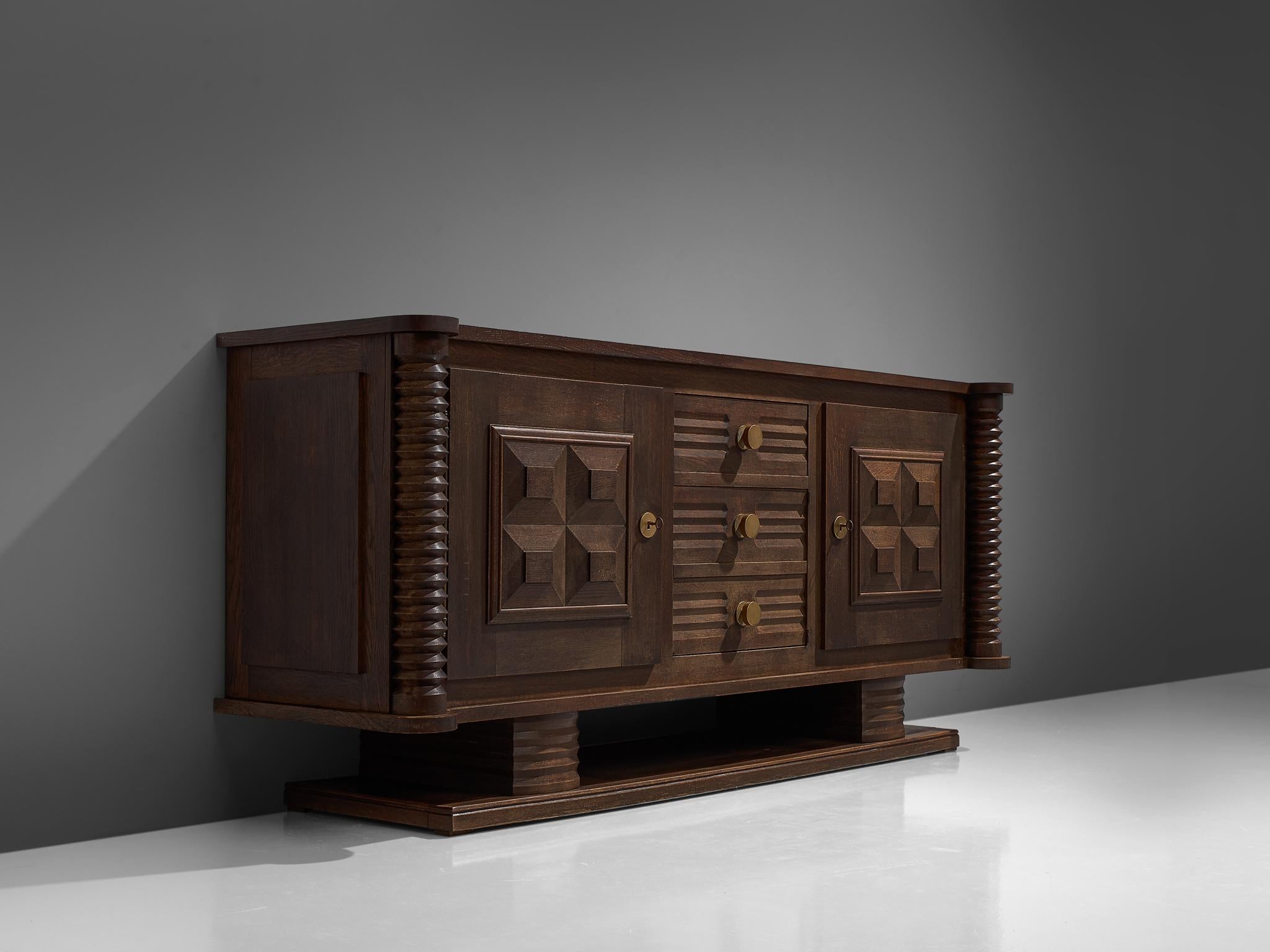 Charles Dudouyt, credenza, wood, circa 1925.

This sturdy credenza in oak with cilinder wood work is a truly sculptural piece. This two-door and three-drawers sideboard is equipped with several shelves and drawers which provide plenty of storage
