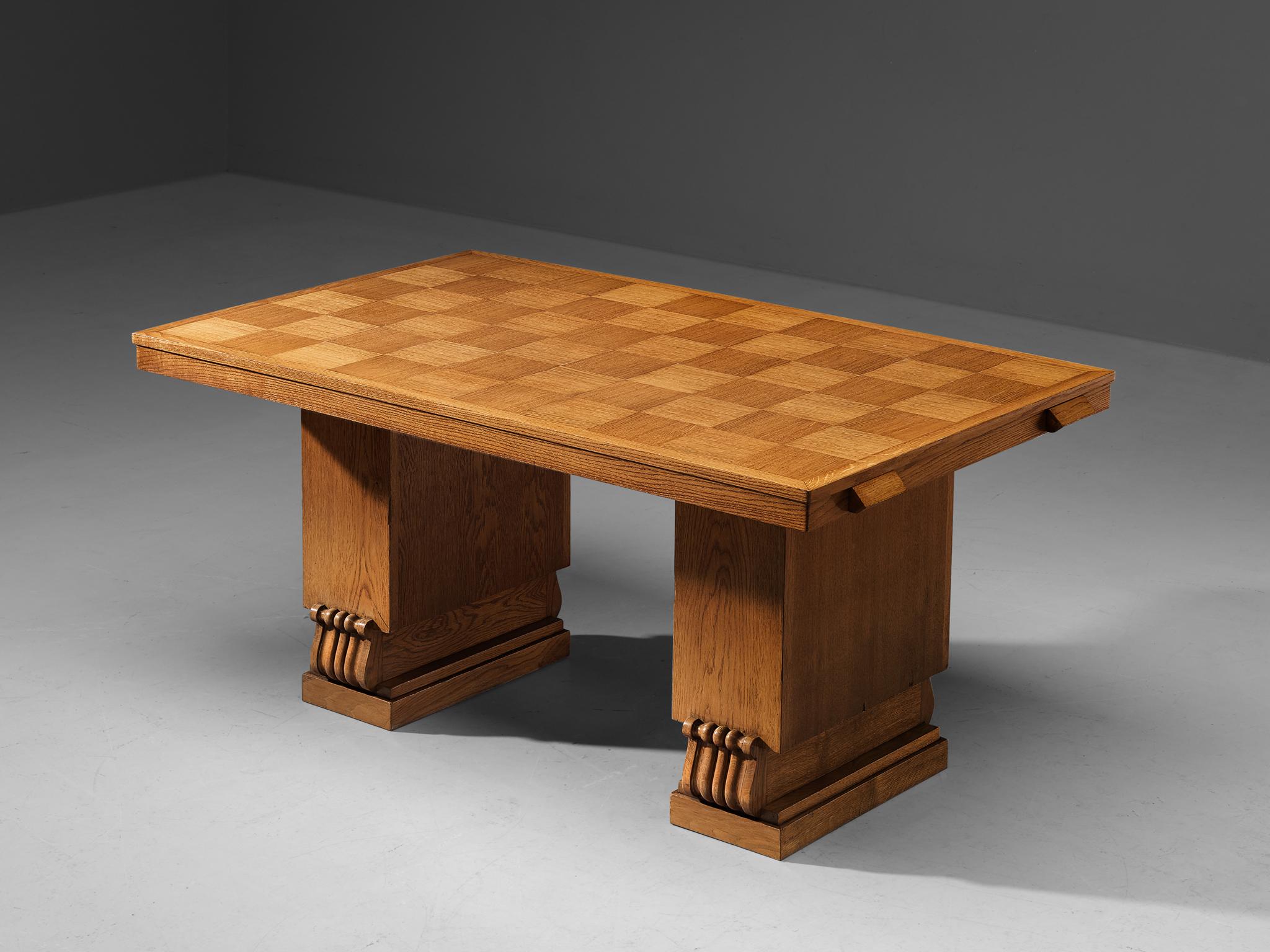 Charles Dudouyt, dining table, oak, France, 1940s.

This well-designed dining table is architectural in its structure and alludes to the stylistics traits of the artistic Art Deco movement of the 1940s. The top has a checkered pattern that is