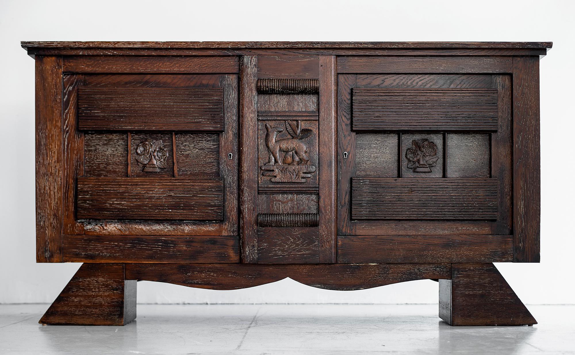 Amazing French dark cerused oak sideboard attributed to Charles Dudouyt, circa 1930s. 
Incredible hand carved front with 2 doors with open storage.
Gorgeous lines throughout. 
Incredible piece!