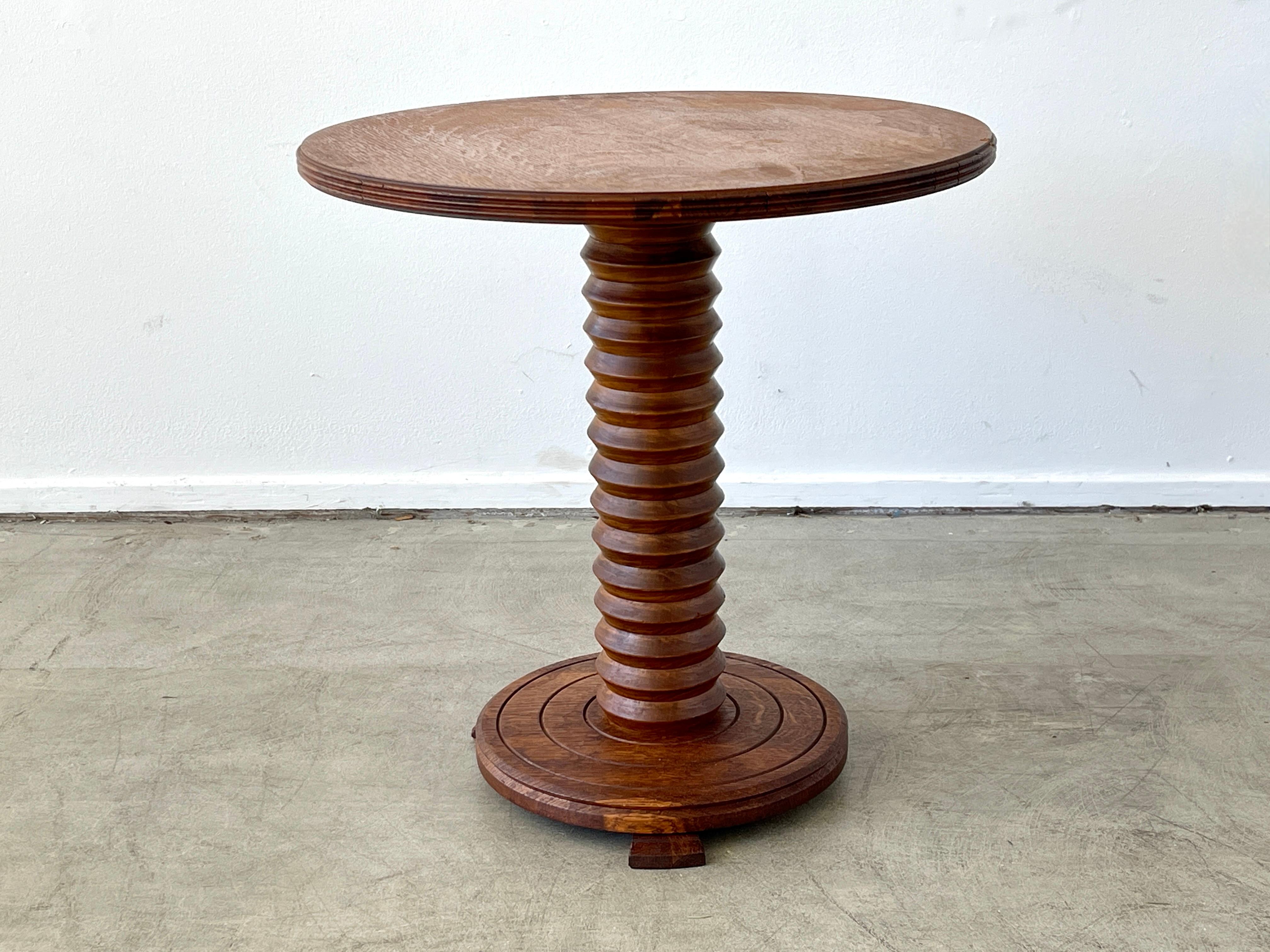 Charles Dudouyt attributed table with signature corkscrew base and wonderful oak patina.
Carved concentric circled base with wood glides