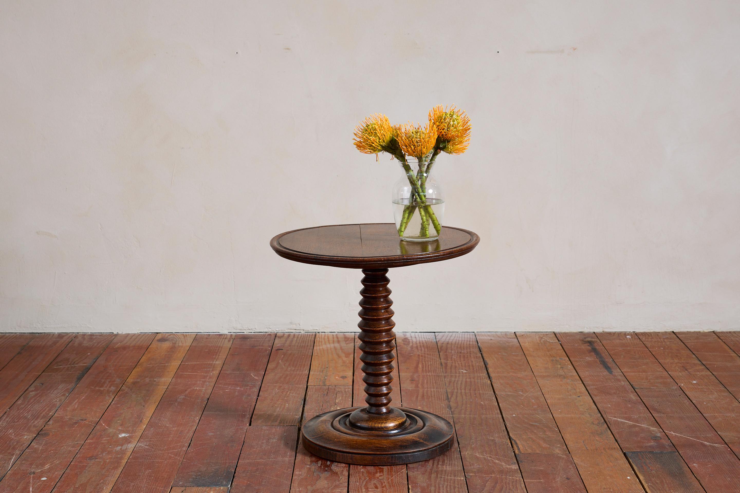 Fantastique table d'appoint Charles Dudouyt avec sa base sculptée en tire-bouchon de forme unique. 

Base circulaire concentrique et détails de la corniche sculptée sur le dessus.

Belle patine d'usage. 

France, vers les années 1940.