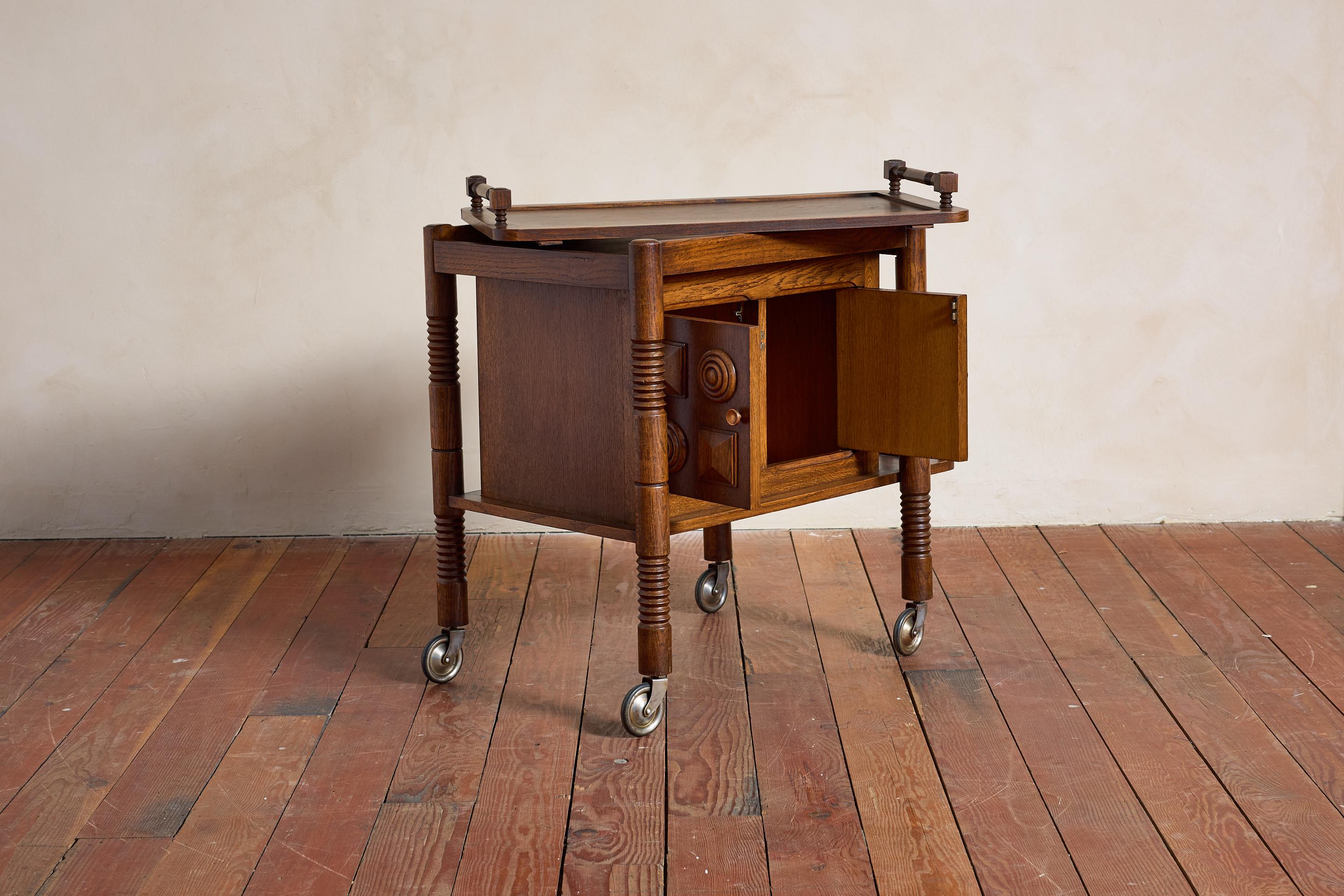 Mobile bar Charles Dudouyt - Francia, anni '40 

Due sportelli anteriori con portaoggetti interni e vassoio superiore rimovibile

Scomparto laterale per riporre le bottiglie.

Cavatappi caratteristici e dettagli in legno intagliato.

Un pezzo super