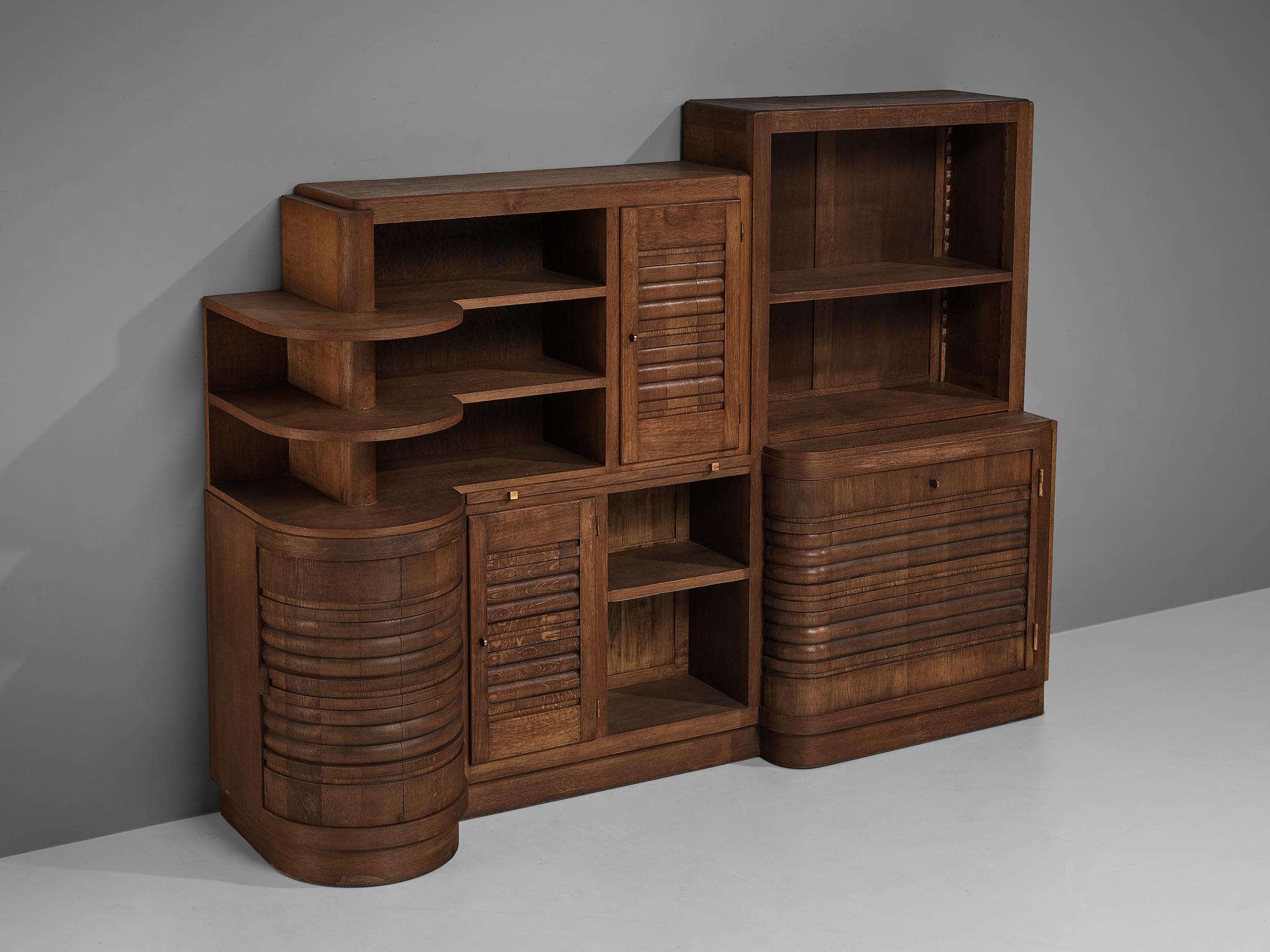 Charles Dudouyt, highboard, oak, France, circa 1937. 

Rare solid oak cabinet designed by Charles Dudouyt. Its variety of shape and heights create an overal dynamic appearance which is amplified by the horizontal carved lines on the doorpanels,