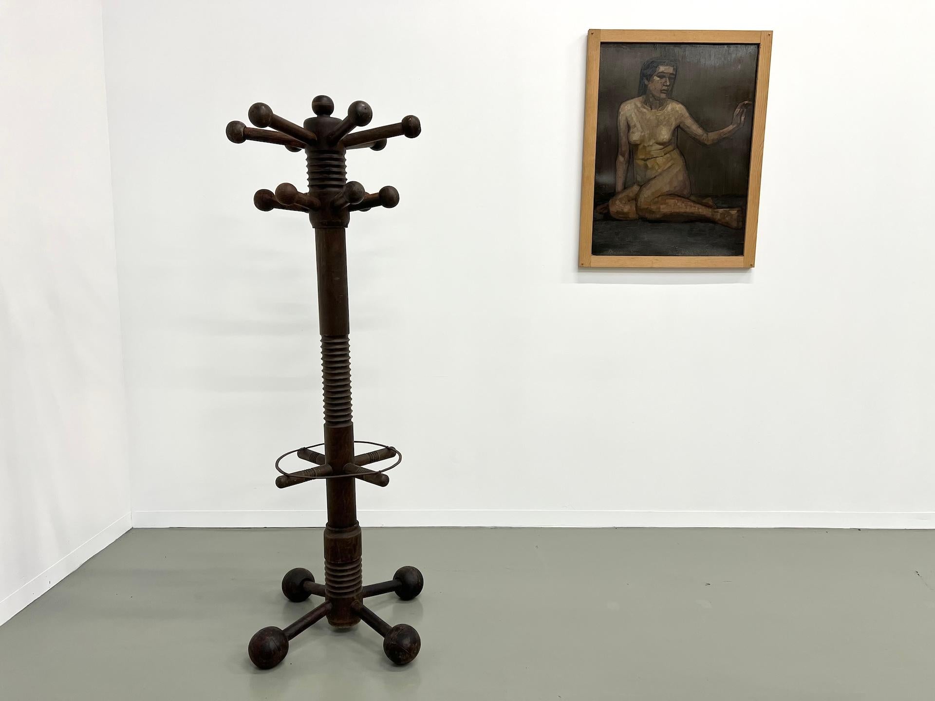 We presents this iconic oak coat rack by Charles Dudouyt (1845-1946), with its 4 ball feet, made in France in the 1940s. Two rows of ball hooks and metal ring to hold umbrellas or various objects.

In a style characteristic of his work mixing