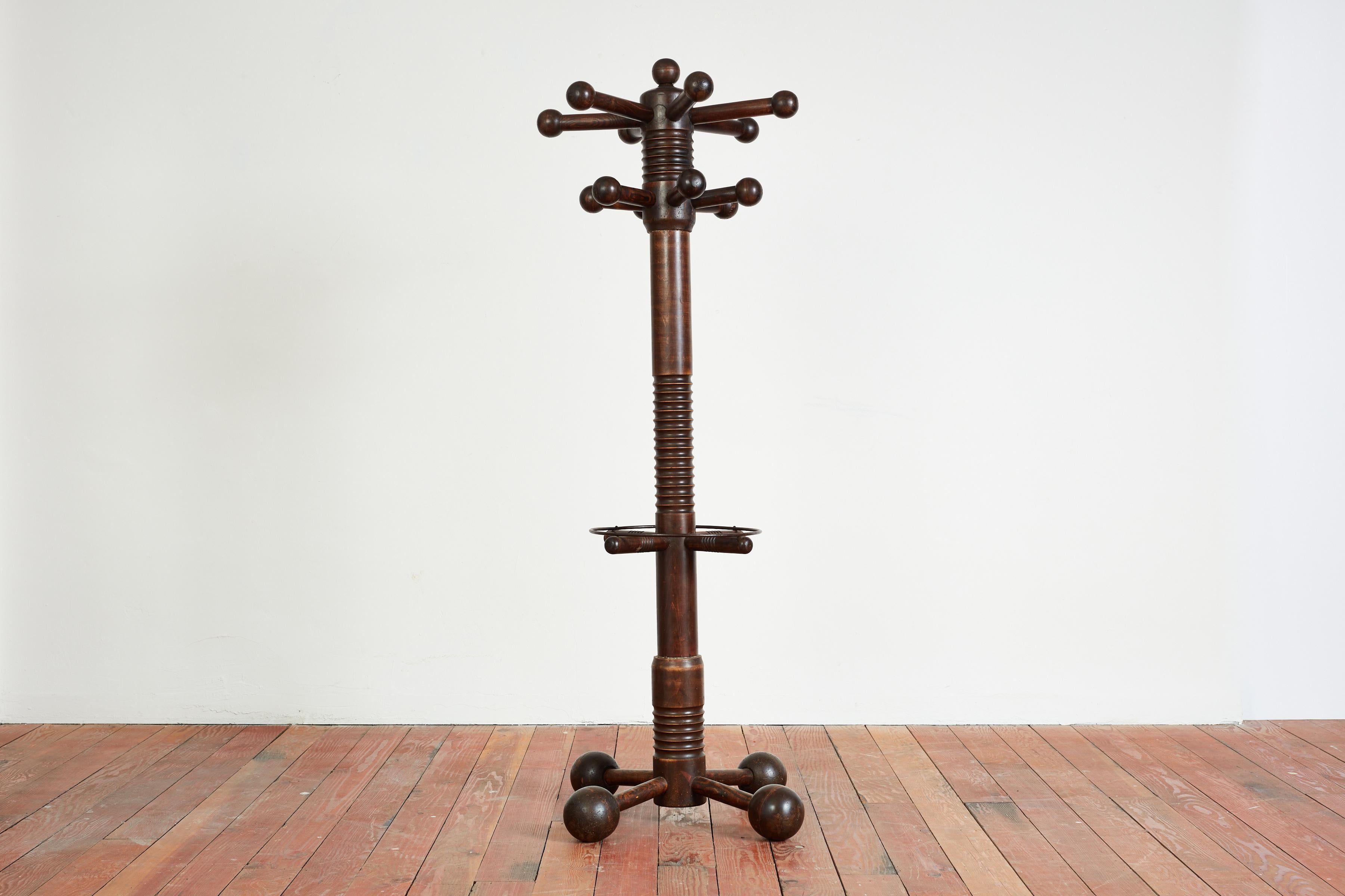 Charles Dudouyt freestanding coatrack with signature bulbous ball tripod base with corkscrew base. 
Two rows of balled coat hooks and metal ring to hold umbrellas / or miscellaneous items. 
Large in scale and extremely well made - a unique piece