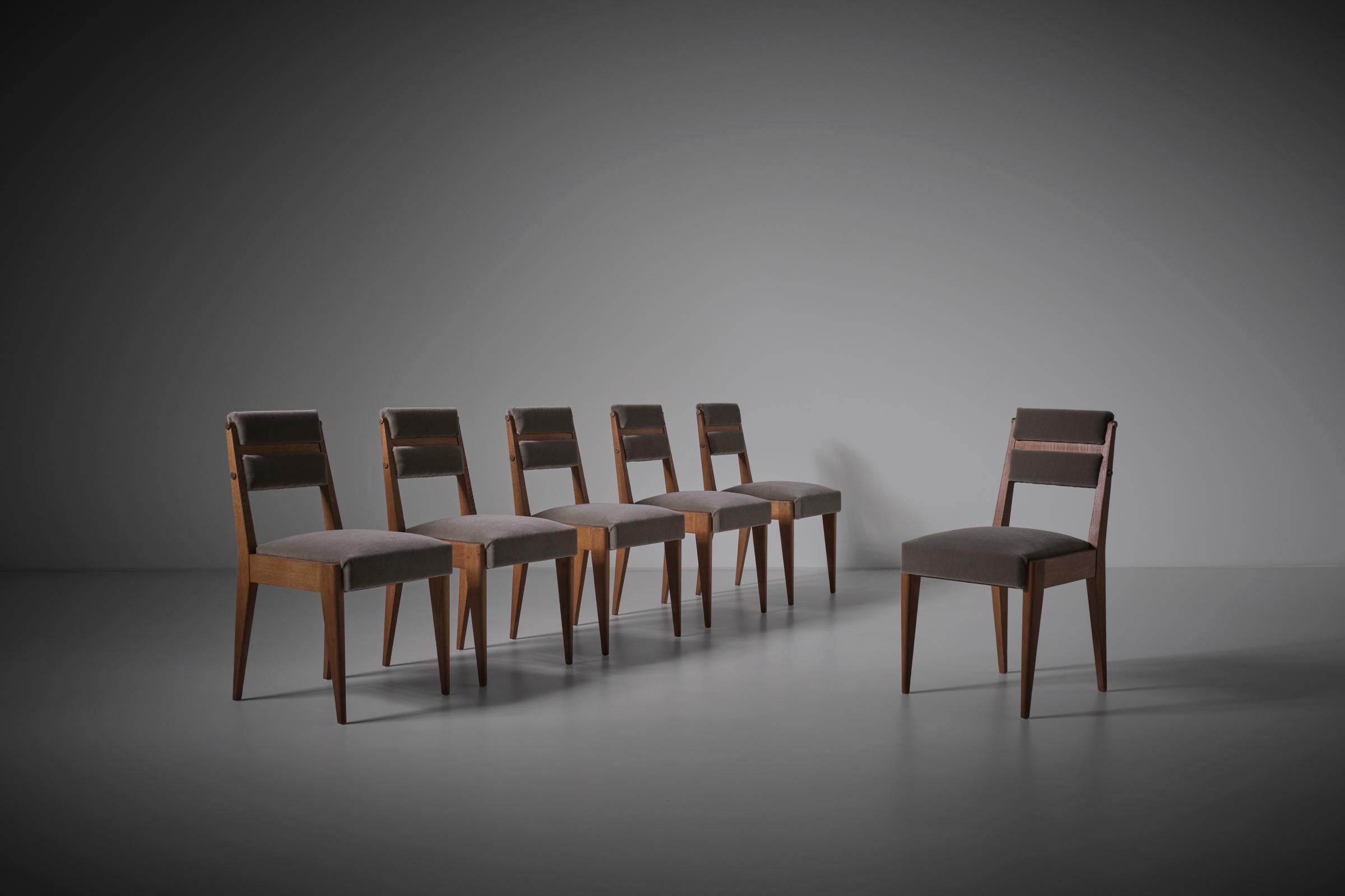 Exceptional set of six dining chairs by Charles Dudouyt for La Gentilhommière, France 1940s. Beautiful sharp lines in nice French Oak with minimal yet strong decorative details such as the brass knobs and the line play. The cushions are