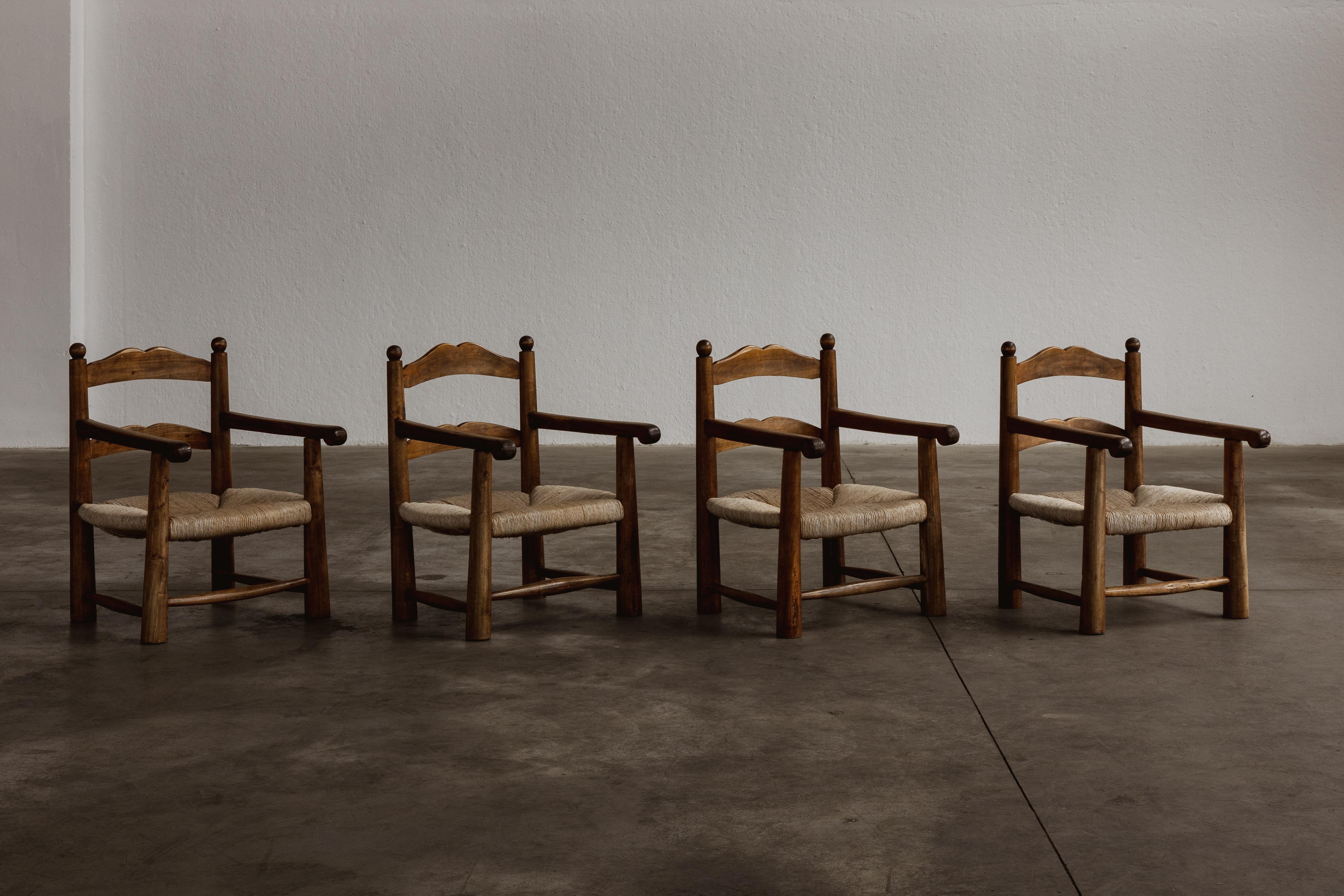 Charles Dudouyt easy chairs, straw and wood, France, 1940s, set of four.

Recalling the turned chair model, Charles Dudouyt created these carved chairs as 'fireside' chairs, hence the low seats. Using playful geometries and construction, he crafted