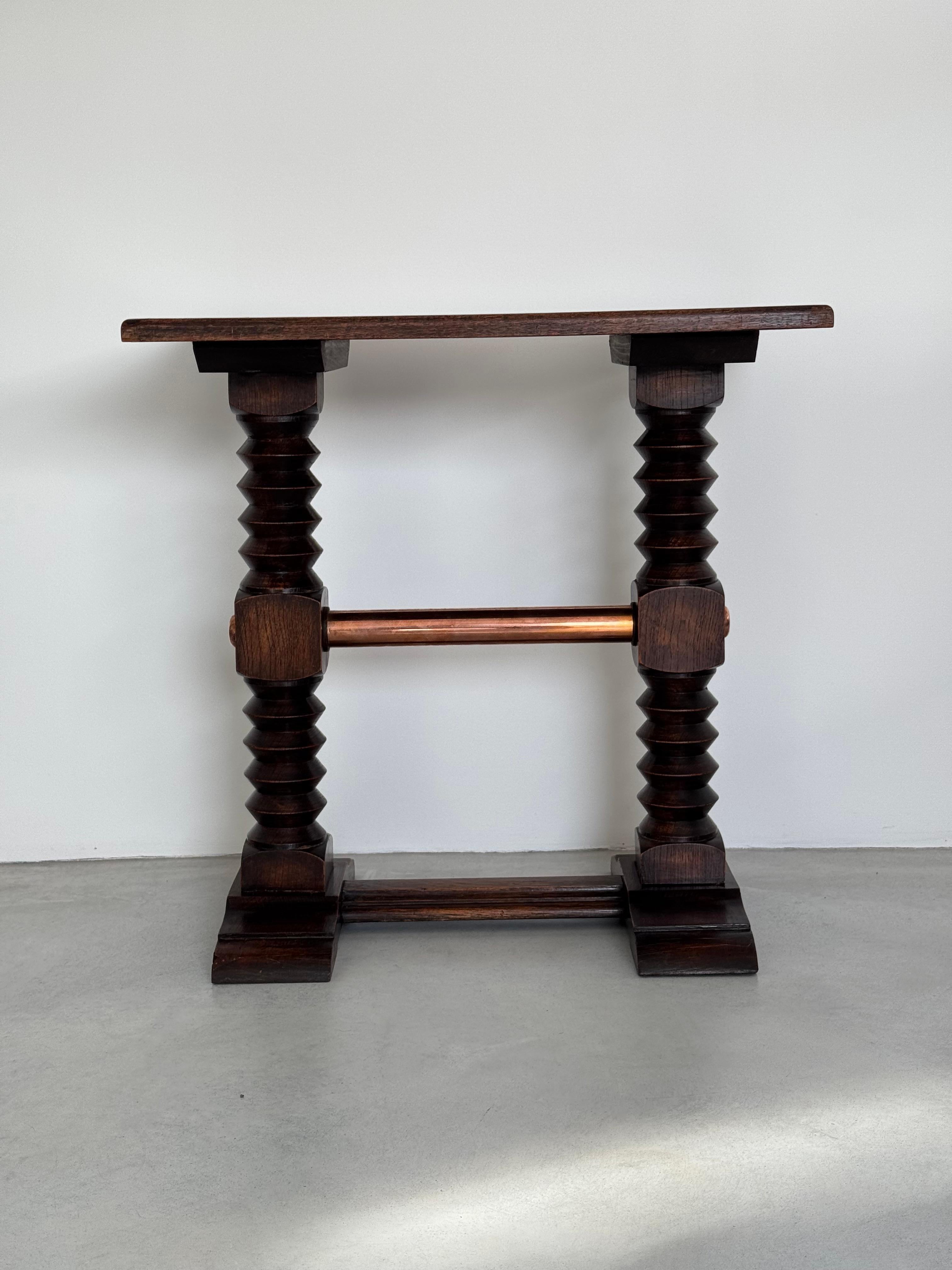 Rare and elegant rectangular side table in solid oak.

Base composed of two turned wooden columns and a cube crossed by a copper cylinder in their centers.

Beautiful rustic chic French design.

By Charles Dudouyt, French decorator.

Superb original