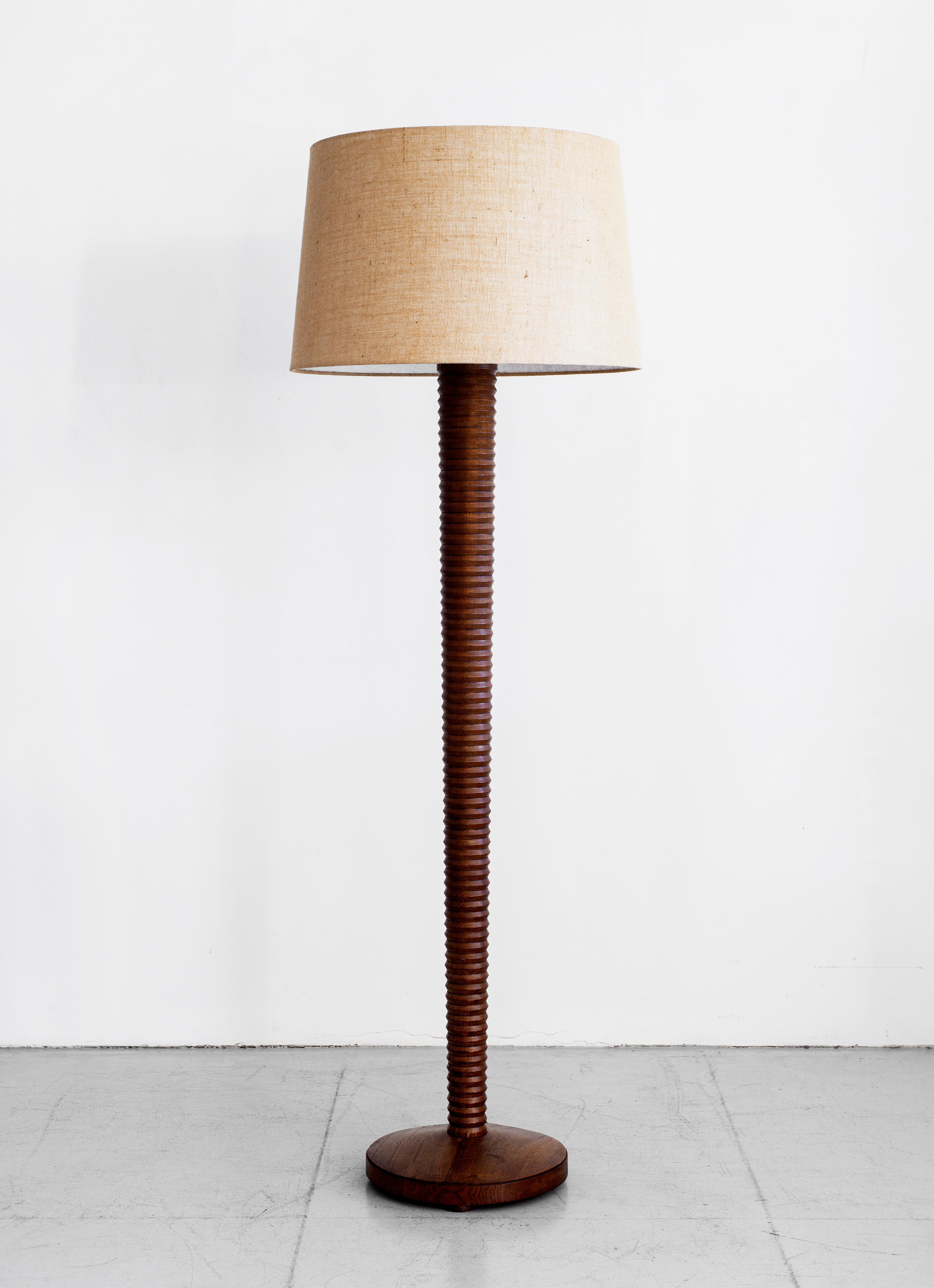 Impressively sized walnut wood floor lamp by Charles Dudouyt. Beautiful carved detail on column stem and wood circular base. Newly re-wired with new linen shade. 

Shade measures: 27