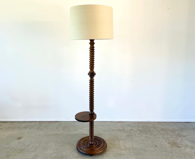 Charles Dudouyt floor lamp with signature corkscrew carved base and floating asymmetrical table. Round ball feet are a nice detail to the carved base. 
New linen shade / newly rewired.
