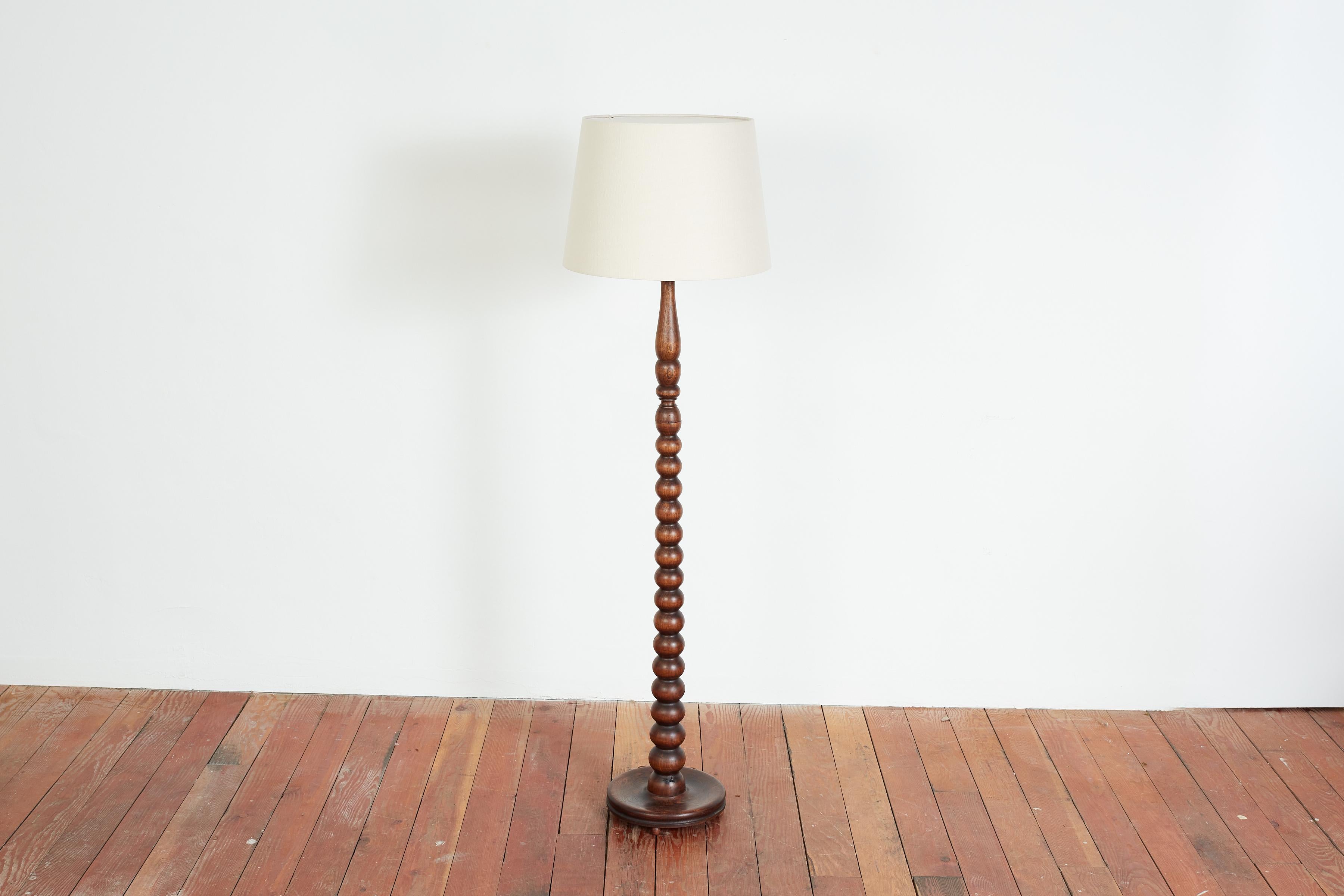 Charles Dudouyt attributed standing floor lamp with intricately carved turned wood and new linen shade and circular base with round feet. 
Wonderful patina to wood. 

France, circa 1940s.

