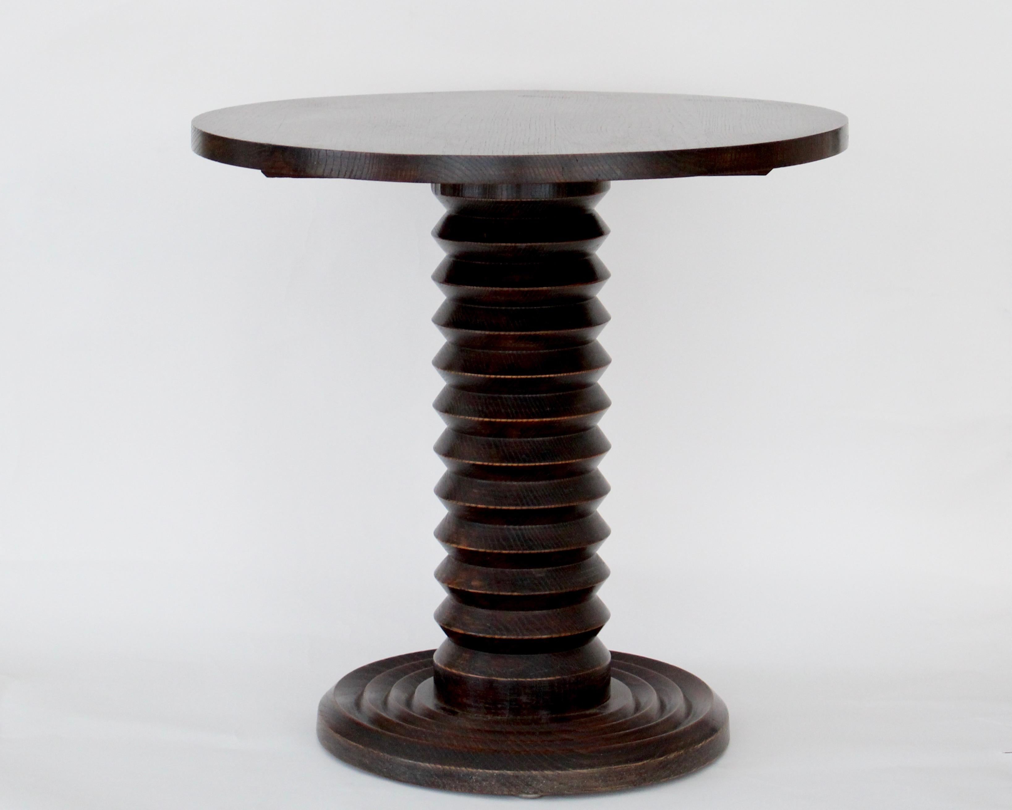 Charles Dudouyt French dark patinated oak side table or gueridon, c 1930.
Dudouyt's work was often characterized by the very dark patina he used on the oak and the corkscrew motif on the table center portion.
 