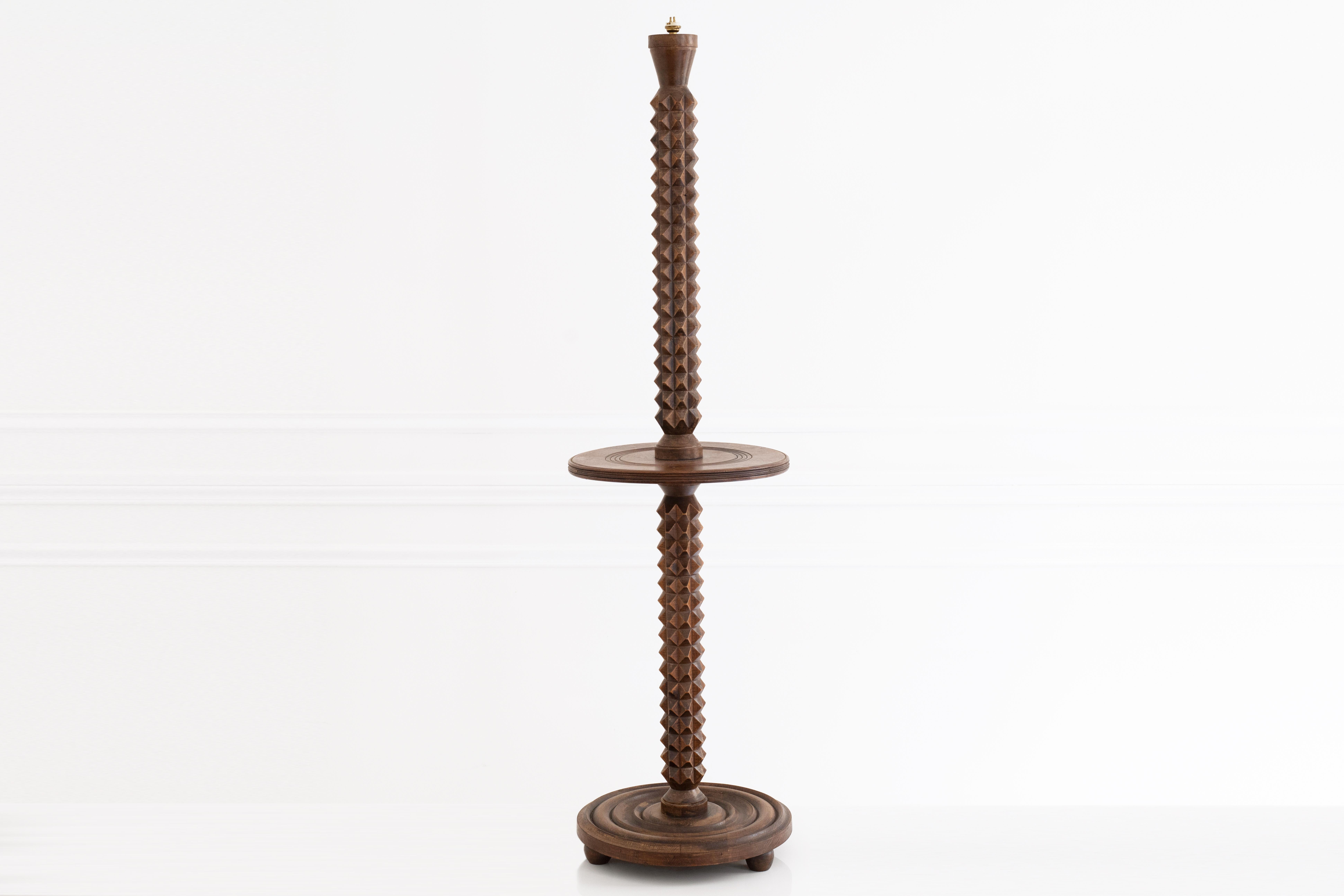 This sculptural floor lamp in walnut by Charles Dudouyt from the 1940s, features a grooved round base that highlights the wood's natural grain. The central shaft is a diamond-tipped with angular faceted edges adding a modern geometric touch that