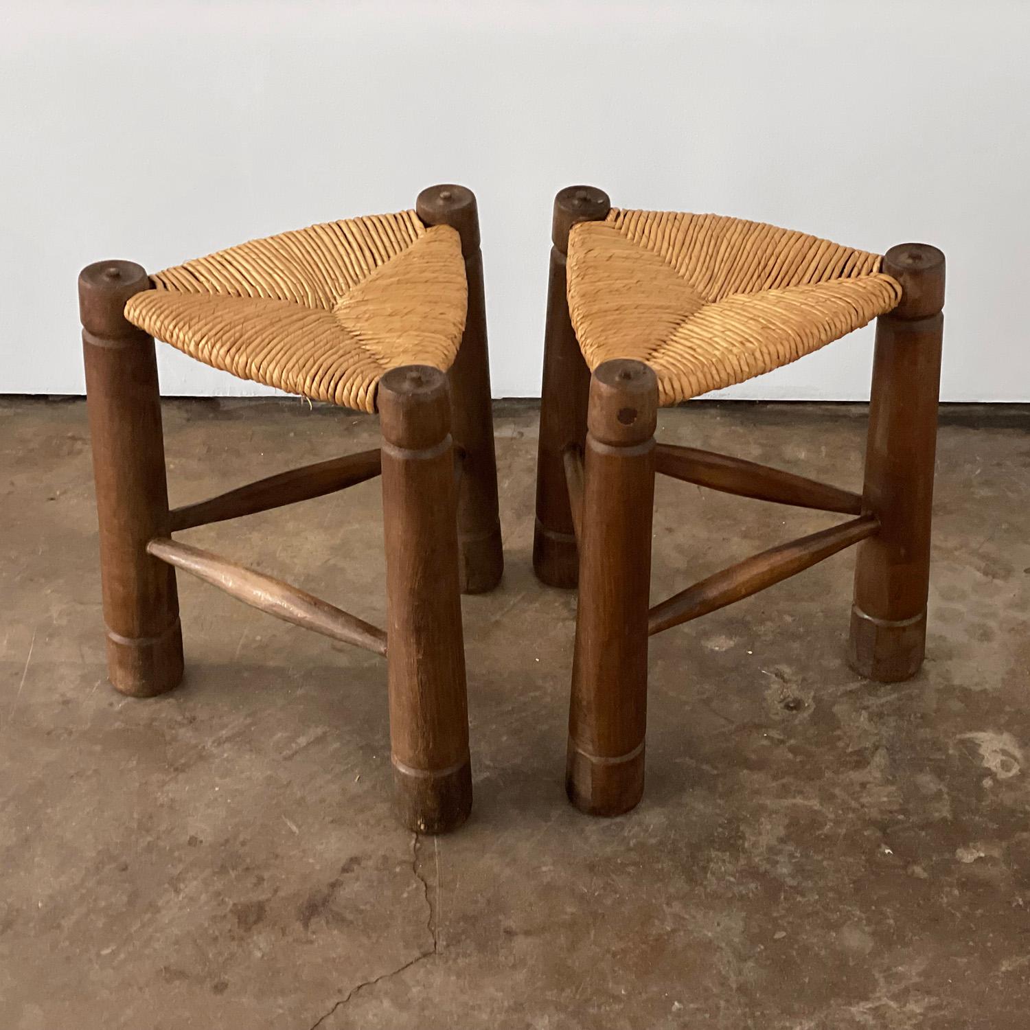 Charles Dudouyt french primitive stools
France, circa 1940's
Signature carved legs and natural woven seat
Patina from age and use 
Minor surface wear
Visible nail head as seen in photo
Sold as a pair
Additional Charles Dudouyt chairs and
