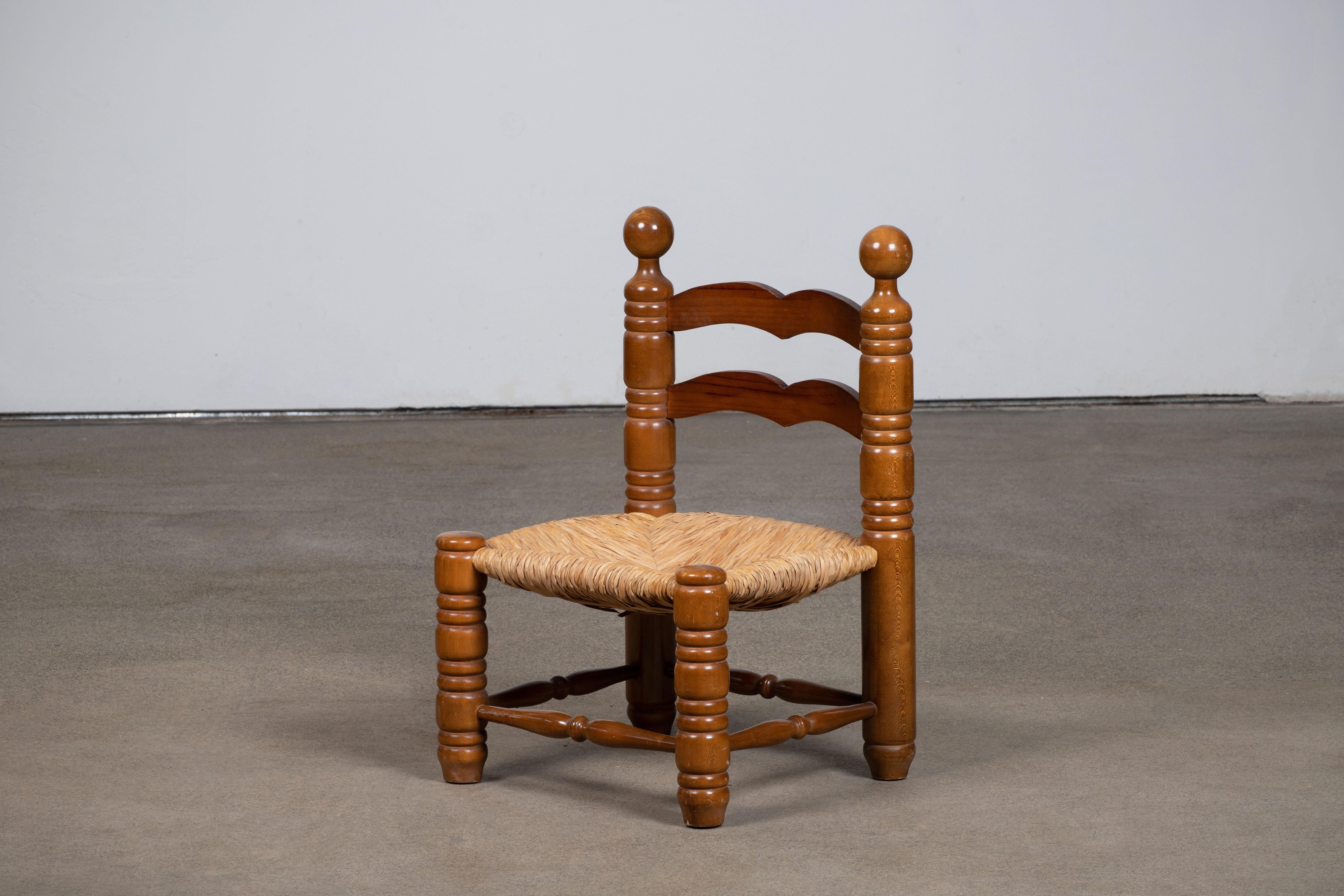 Niedriger Stuhl aus Holz und Stroh, der Charles Dudouyt zugeschrieben wird. 
Charles Dudouyt, eine der wichtigsten Persönlichkeiten des französischen Designs zu Beginn des 20. Jahrhunderts, hat die französische Designästhetik von einem ausgefeilten