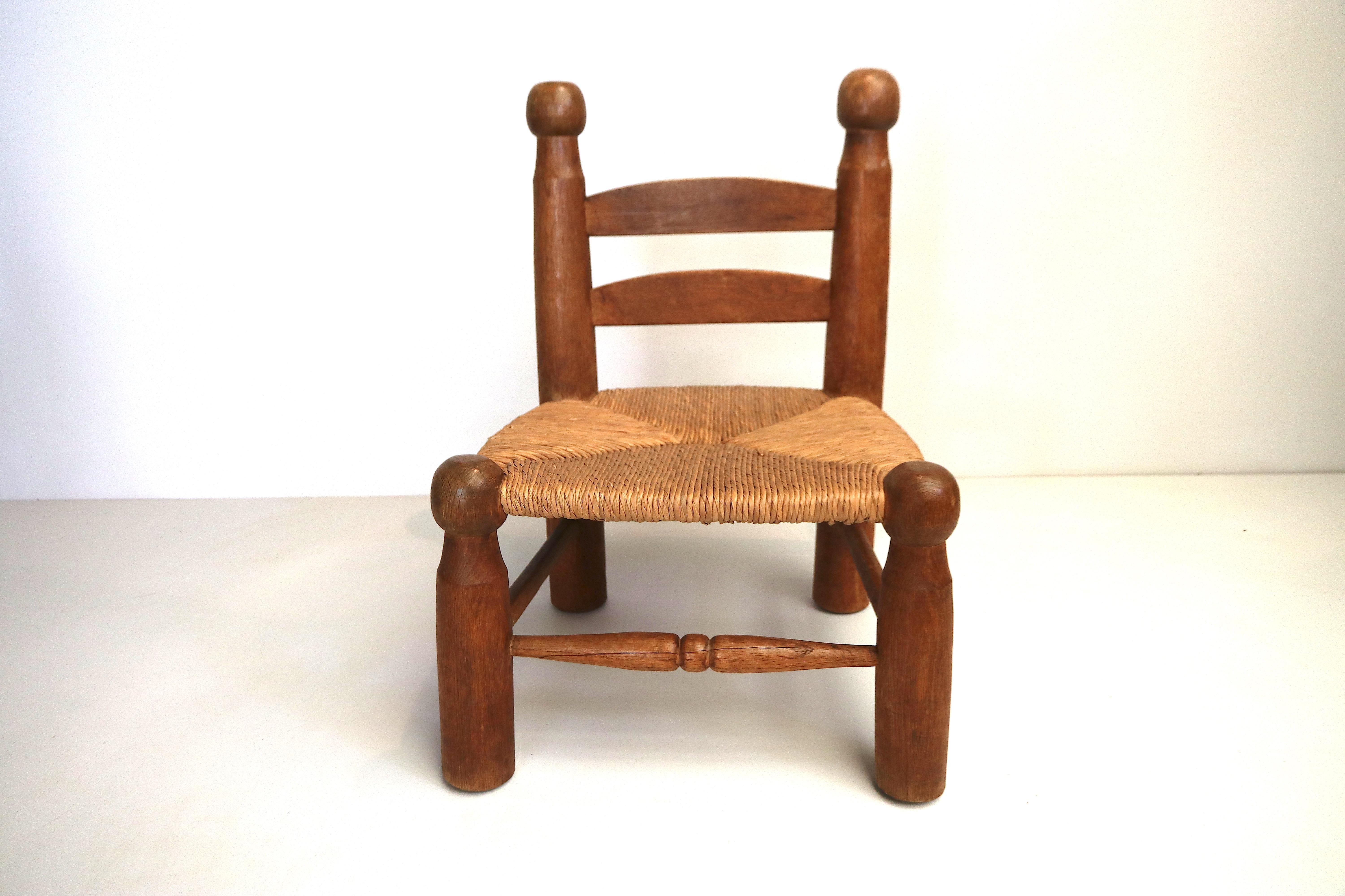 Beautiful example of a rare Charles Dudouyt low side chair in French oak - also called fireside chair- for next to the fire place. This is exactly the right model, with the ball-ends and the cone-shaped lumpy leg ends, the rush seat is in a