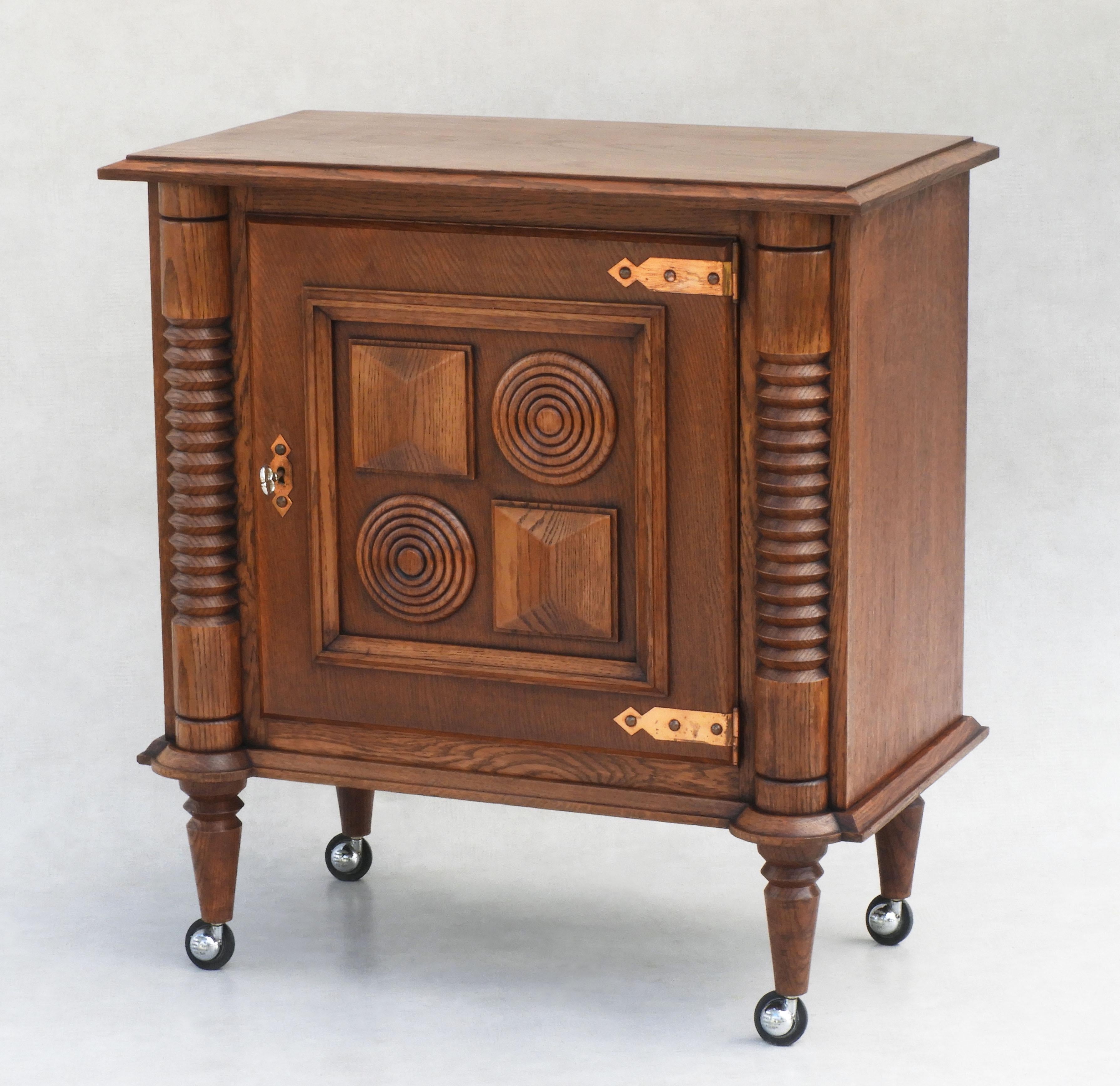 Stunning Oak Rolling Dry Bar Cabinet in the style of Charles Dudouyt/Atelier Gentilhommière C1950.           
Great design and good craftsmanship with beautifully turned columns, carved geometric detailing and copper hinges.  Stylish and practical,
