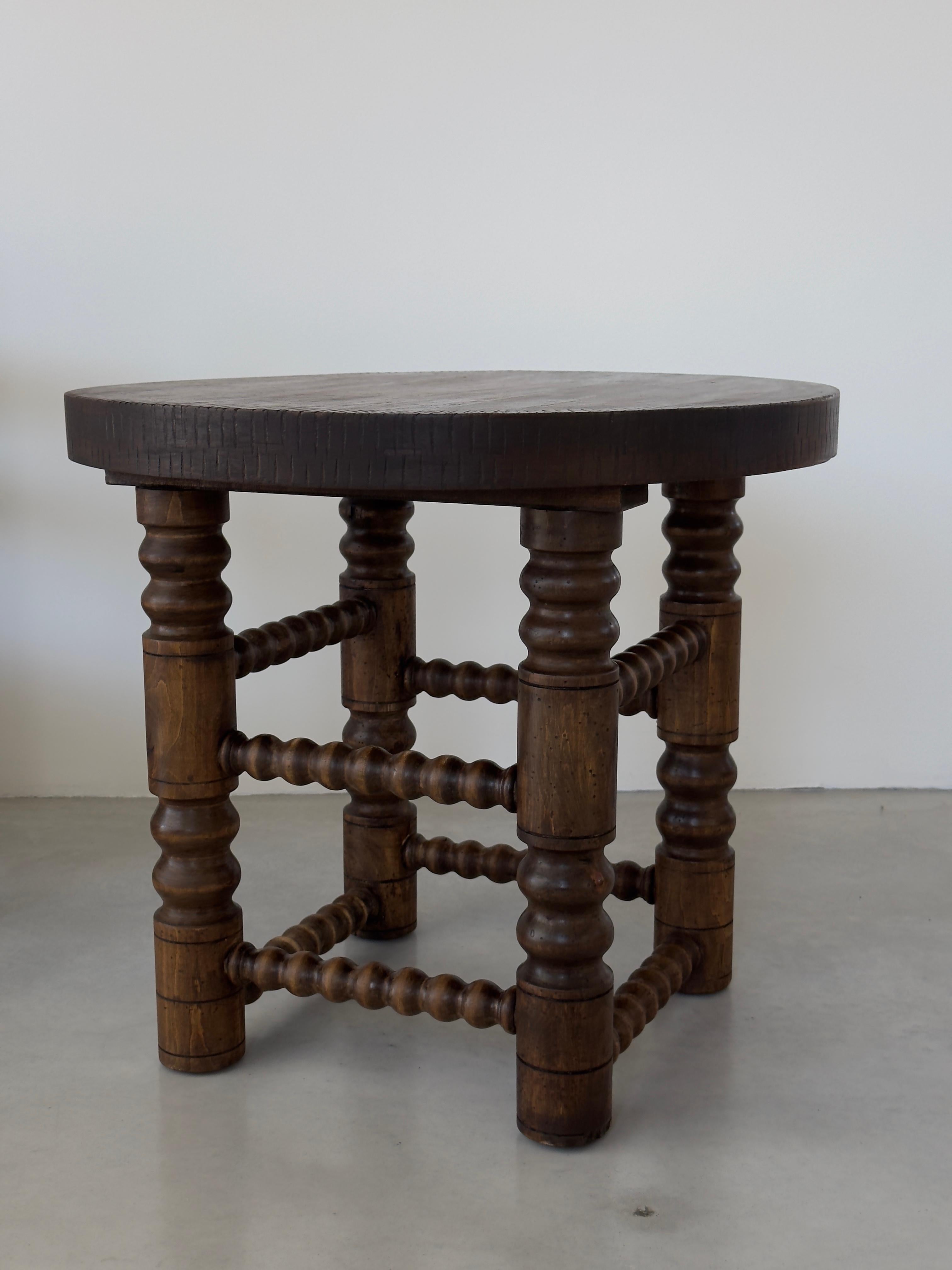 The rustic and chic design of French decorator Charles Dudouyt.

Elegant side table or low pedestal table, turned oak base decorated with rosaries, the top hallmarked with chevrons. Fantastic patina. Traces of an old tool placed on the top and an
