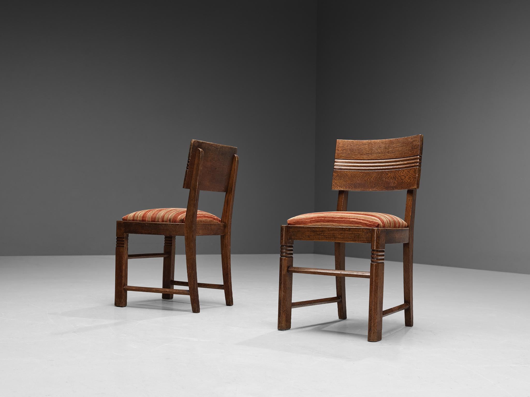 Charles Dudouyt, pair of dining chairs, fabric, oak, France, 1930s 

These beautifully designed chairs are created in one of the most influential periods for the arts namely the Art Deco Movement. The oak frame is based on round edges and