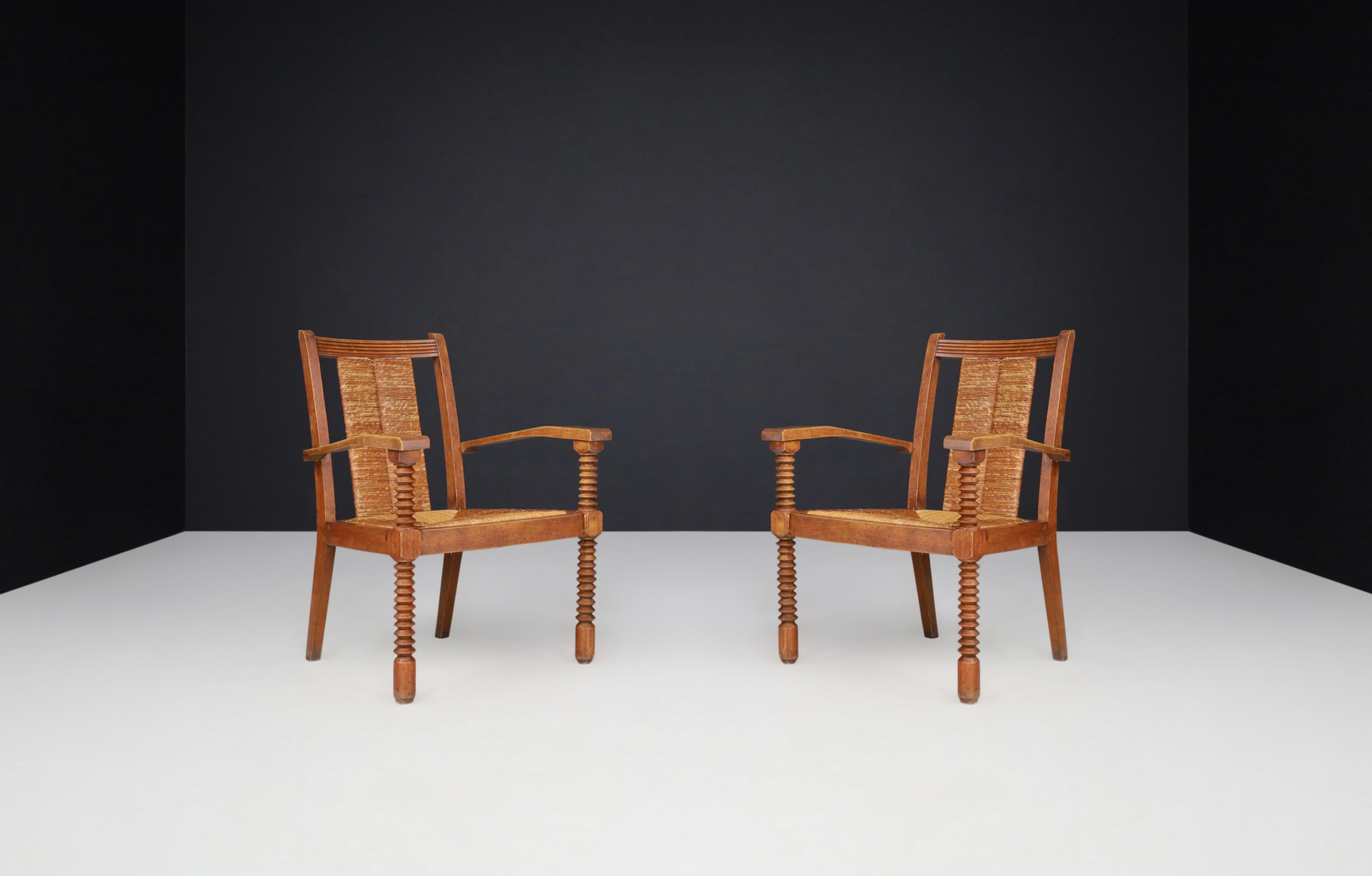 French Provincial Charles Dudouyt Patinated Oak and Rush Armchairs, France 1940s For Sale