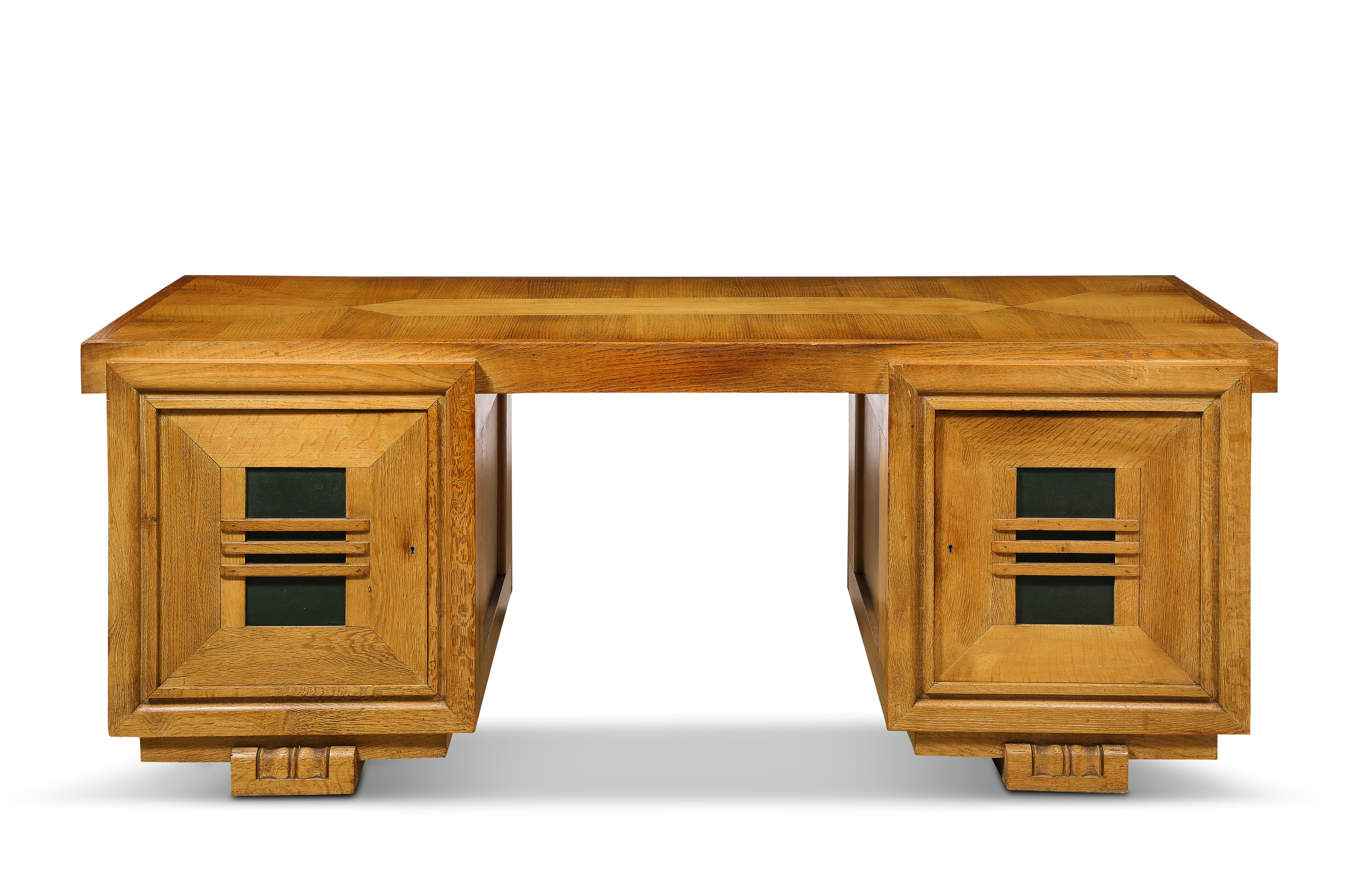 Large double-sided desk by Charles Dudouyt in oak and green leather, each pedestal opens on both ends so the desk can be used as partner’s desk as well as a solo desk.