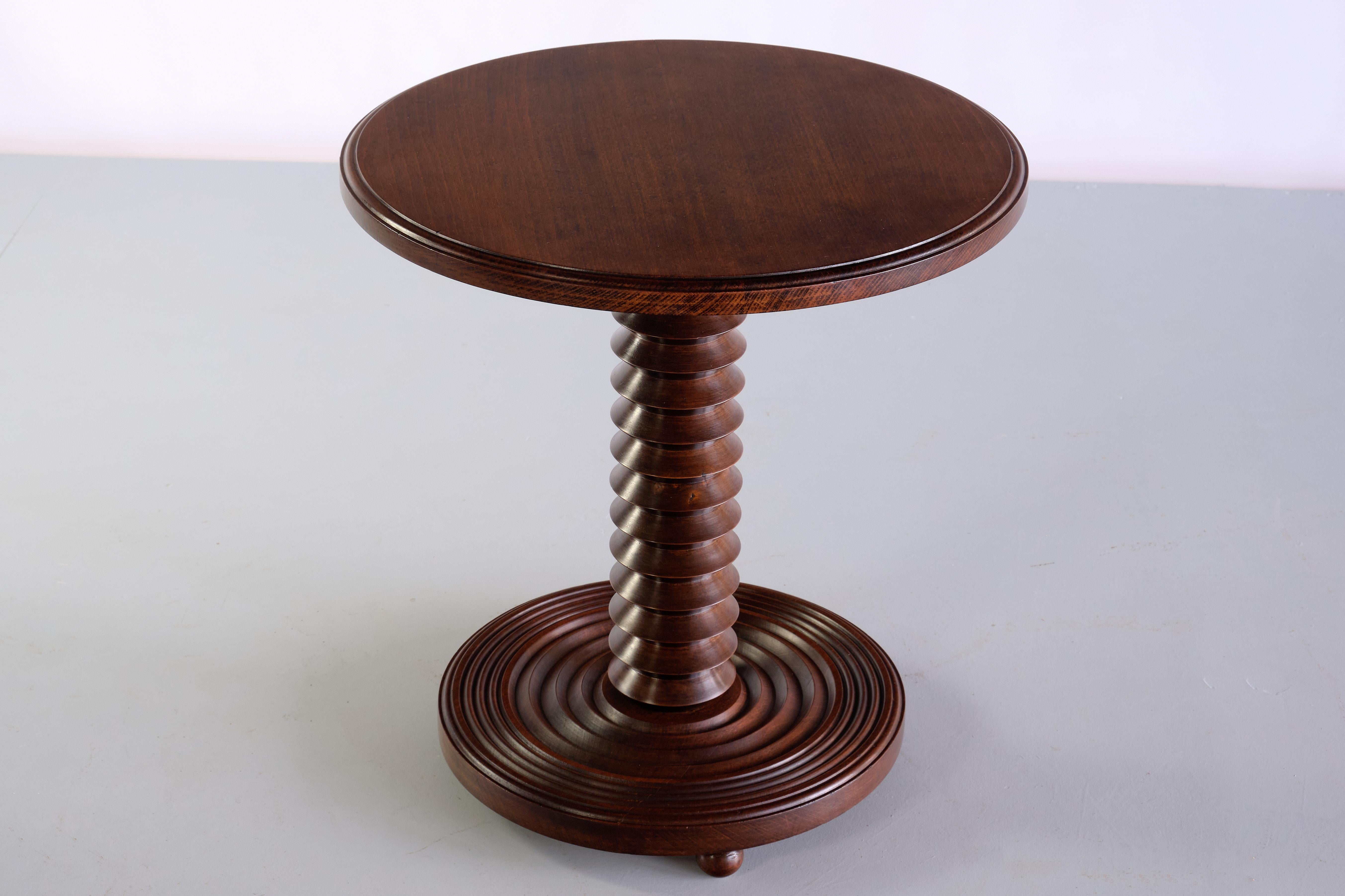 This striking side table was designed by Charles Dudouyt and produced in France in the late 1940s. The round top in solid dark stained oak with a rounded edge. The striking centred column is in turned oak wood, creating a grooved spiral pattern. The