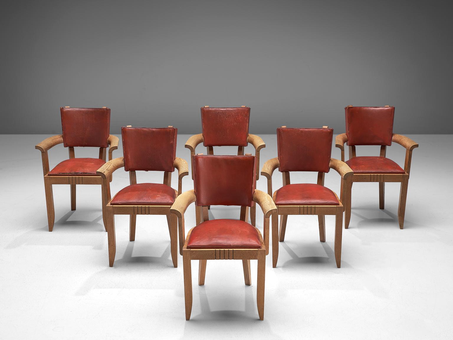 Charles Dudouyt, set of 6 armchairs, leather and oak, France, 1930s

This set of six Art Deco dining chairs is upholstered with deep red leather that has patinated over time. The frame is made of solid oak and features tapered, carved legs. The