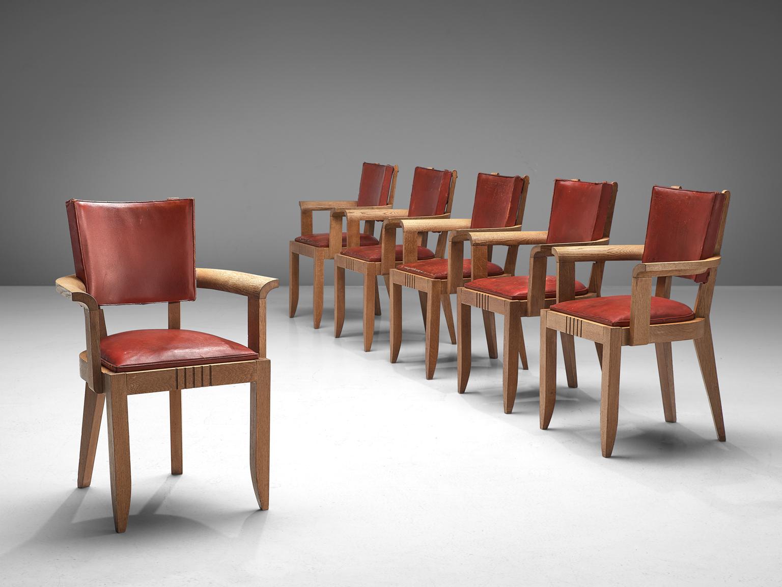 Charles Dudouyt, set of 6 armchairs, leather and oak, France, 1930s

This set of six Art Deco dining chairs is upholstered with deep red leather that has patinated over time. The frame is made of solid oak and features tapered, carved legs. The