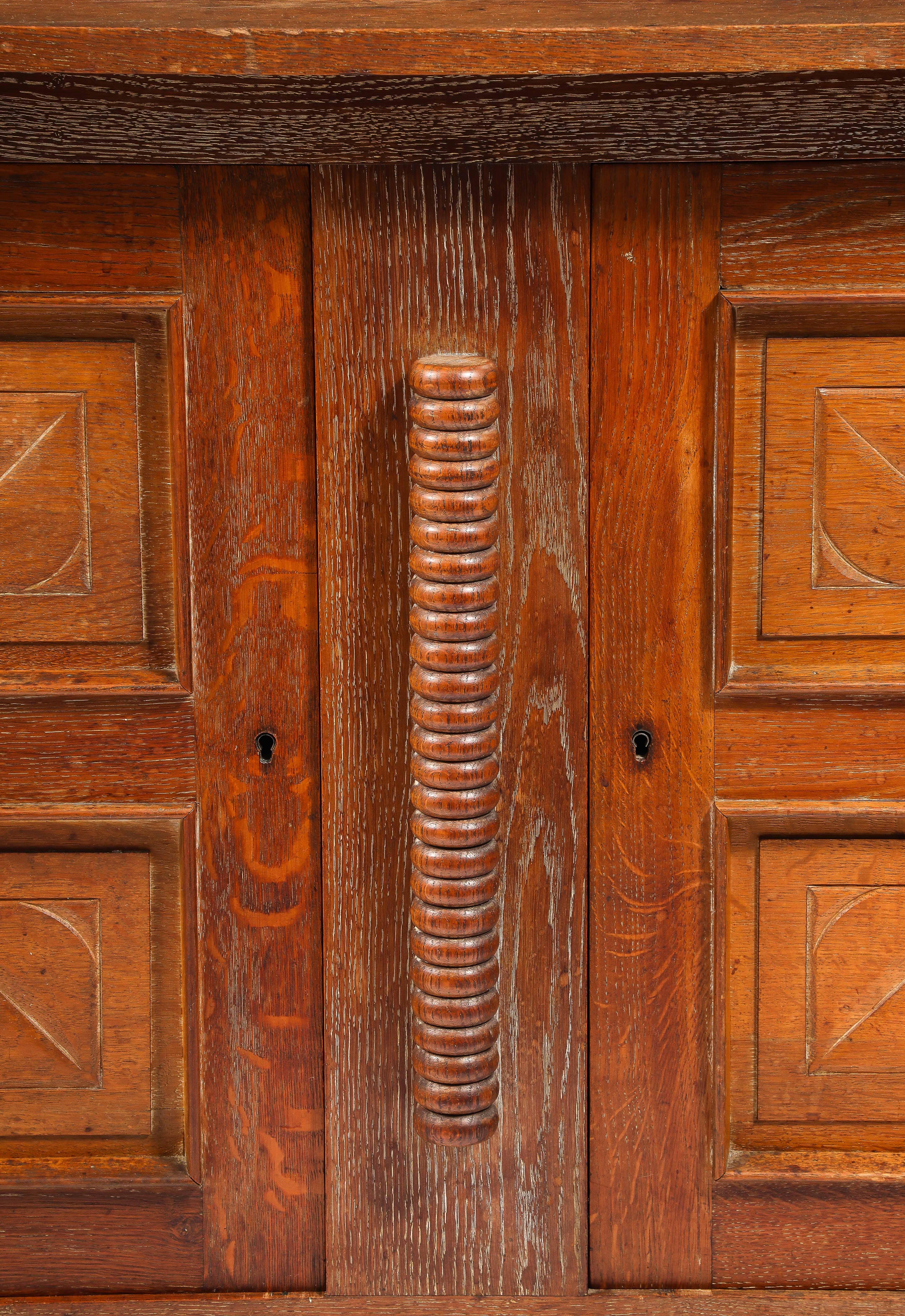 Elegant oak sideboard by Charles Dudouyt with diluted legs and carved doors.