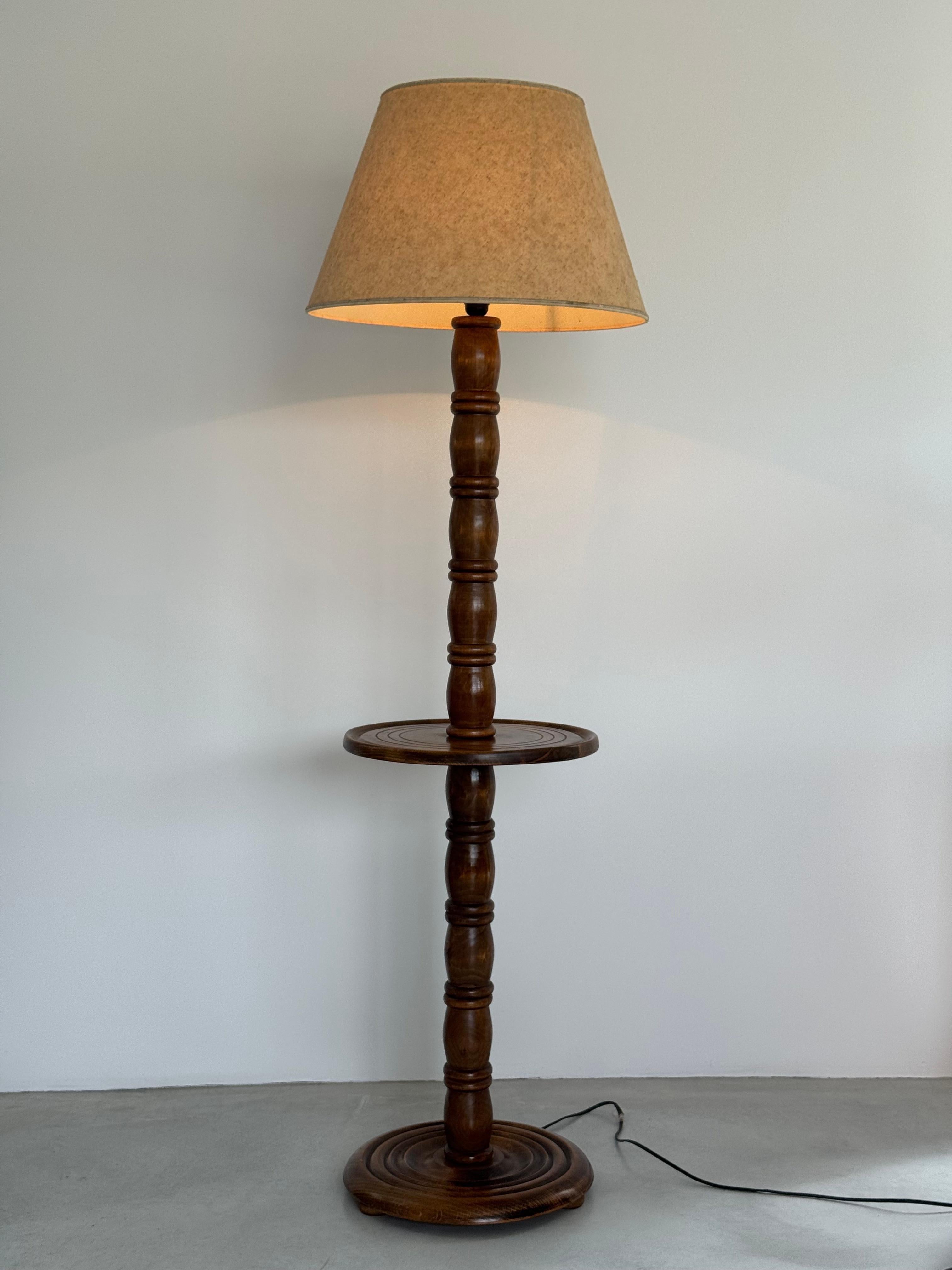 Scopri l'eleganza senza tempo di questa magnifica lampada da terra francese, attribuita al famoso designer Charles Dudouyt e risalente agli anni Quaranta. Realizzato con eccezionale maestria in noce massiccio, questo pezzo incarna lo stile