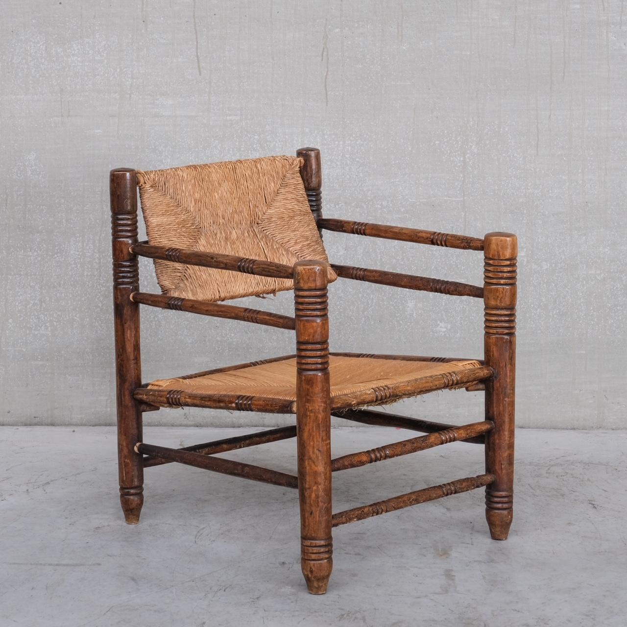 A mid-20th rush and oak armchair. 

France, c1950s. 

In the style of Charles Dudouyt. Wildly stylish with a great stance. 

The oak is worn in places with age and use, the rush on the seat is in good condition, the rush on the back is a