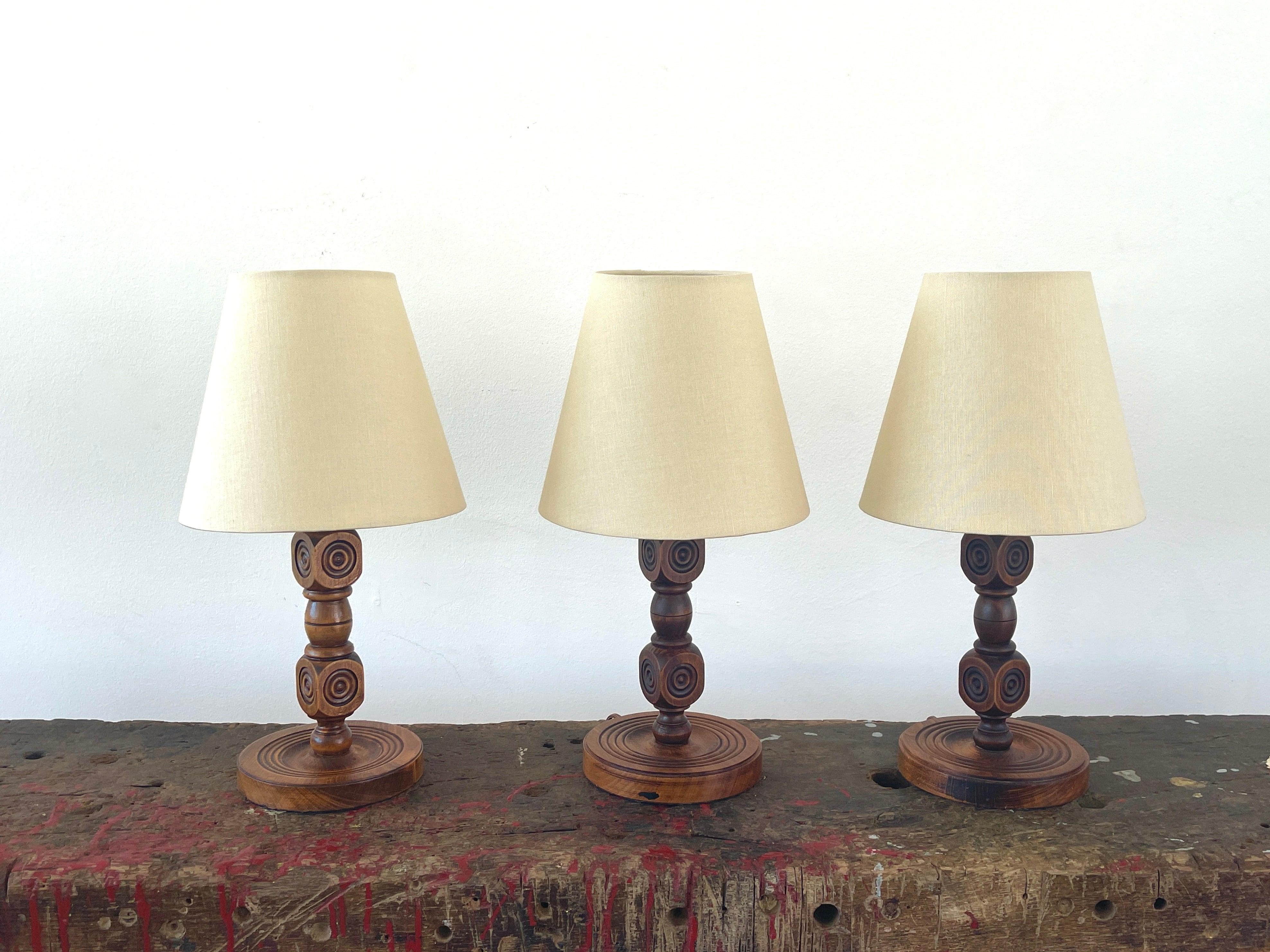 Petite wood carved wood table lamp from France, 1940's by Charles Dudouyt. Beautiful carved wood with great patina. 
New linen shade.
Three available, sold individually.