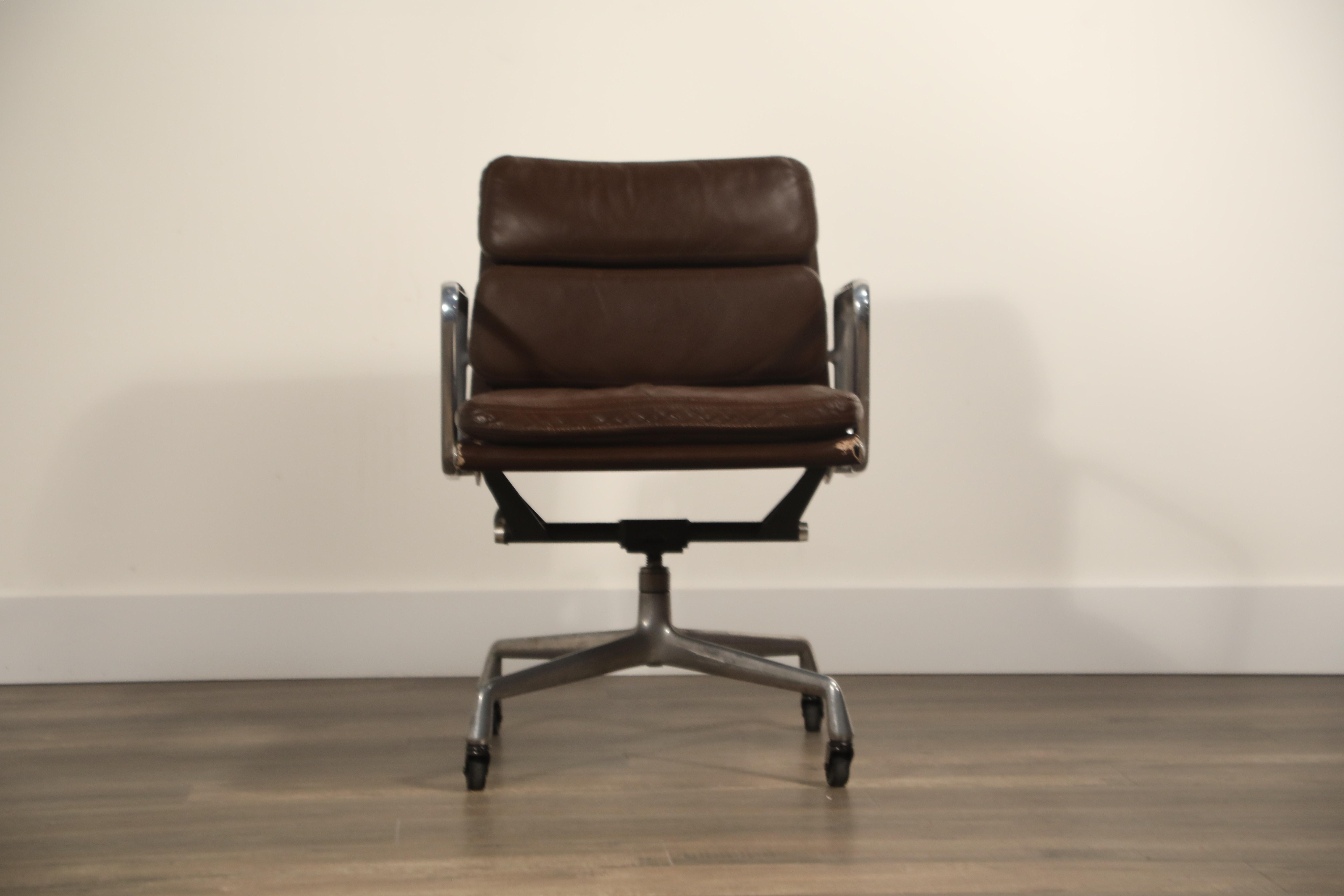 A collectible and sought after soft pad Management desk chair from the Aluminium Group line, designed by Charles and Ray Eames for Herman Miller. Featuring its original vintage dark brown leather upholstery over four-star aluminium base and frame on