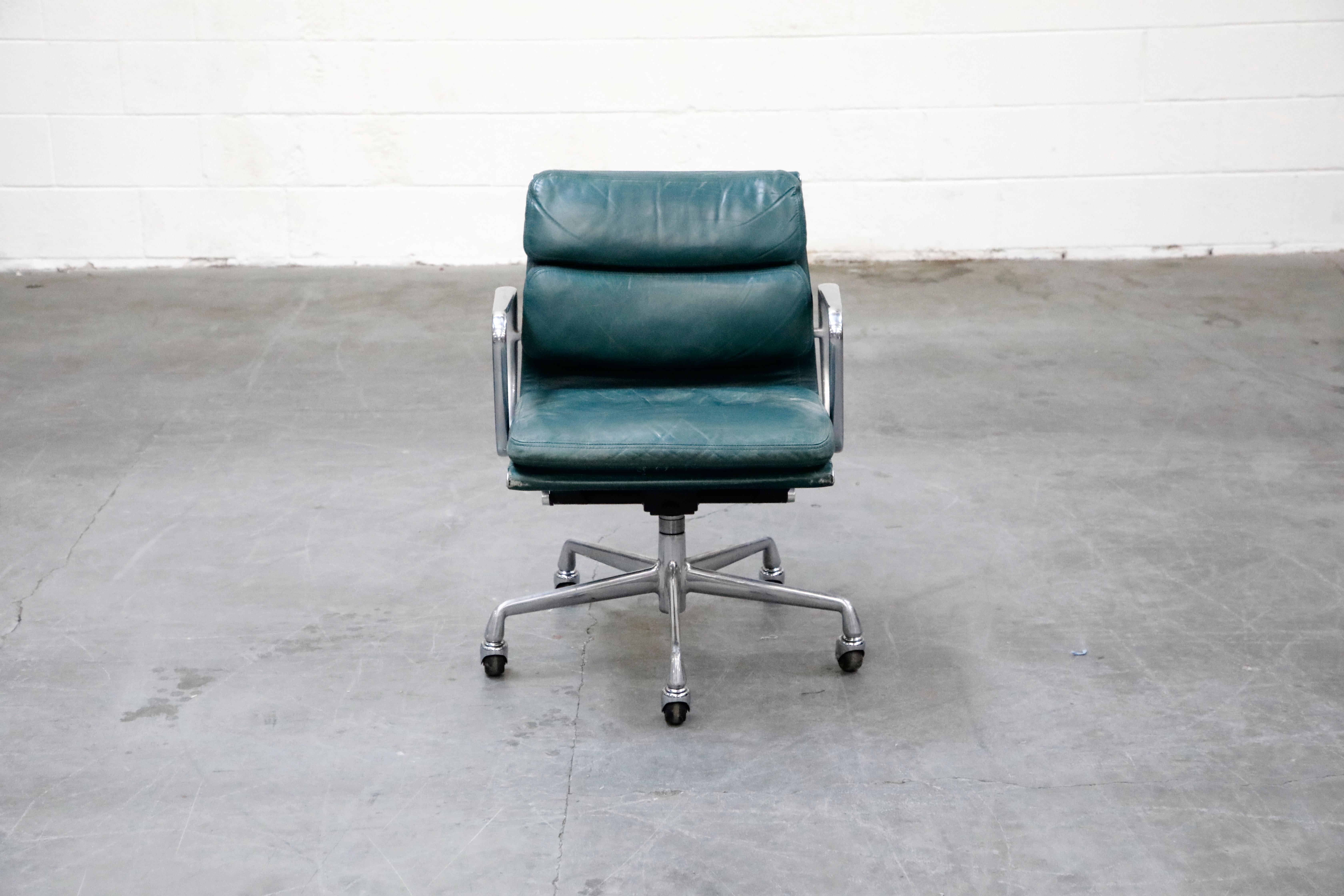 A collectible and sought after leather 'Soft Pad' management desk chair from the Aluminum Group line, designed by Charles and Ray Eames for Herman Miller. Featuring its original vintage green color leather upholstery over five-star aluminum base and