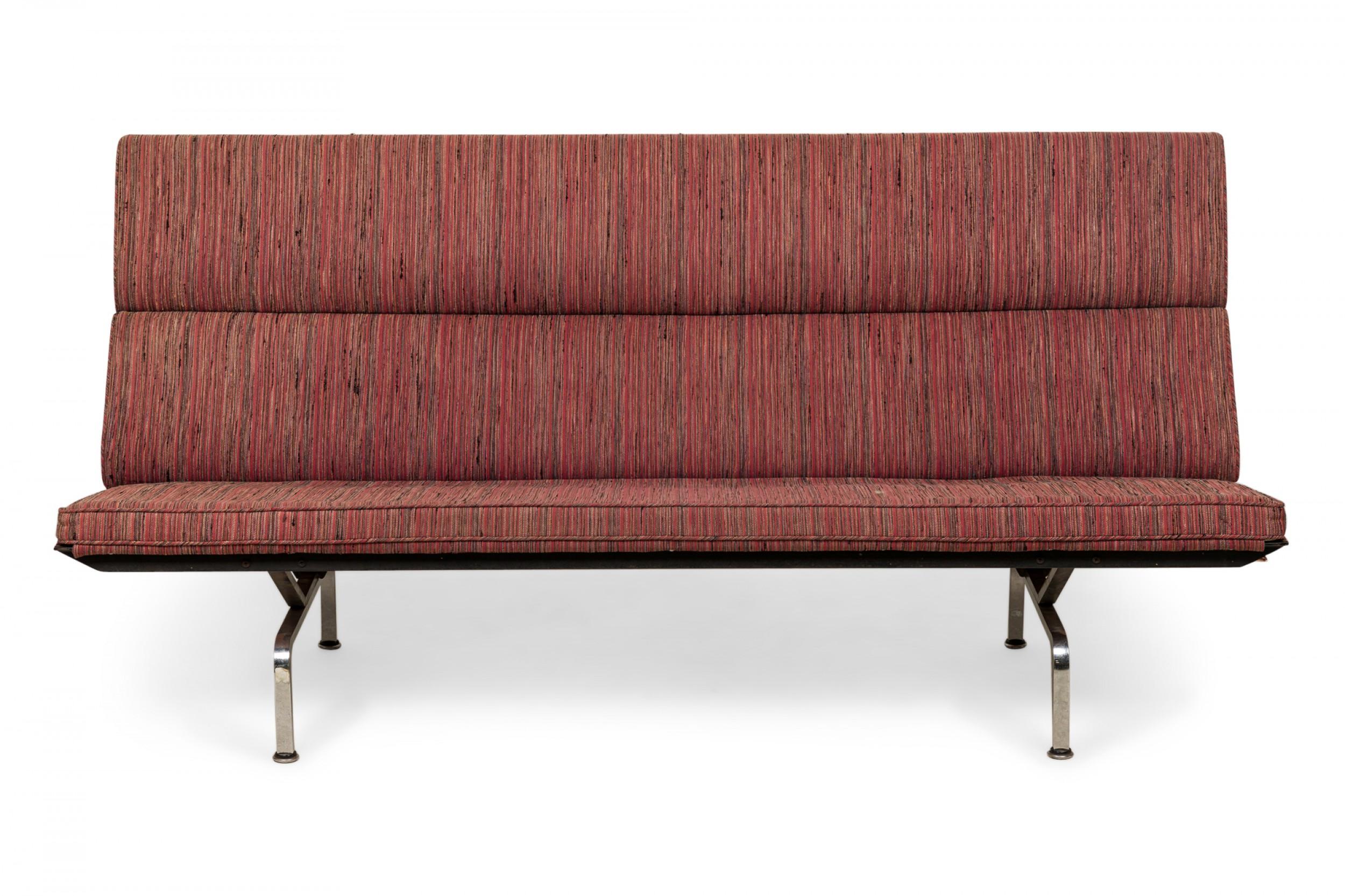 American Mid-Century 'Sofa Compact' folding sofa / settee with red, pink, and orange vertically striped fabric upholstered cushions, resting on four curved chrome legs. (Charles Eames for Herman Miller).
   
