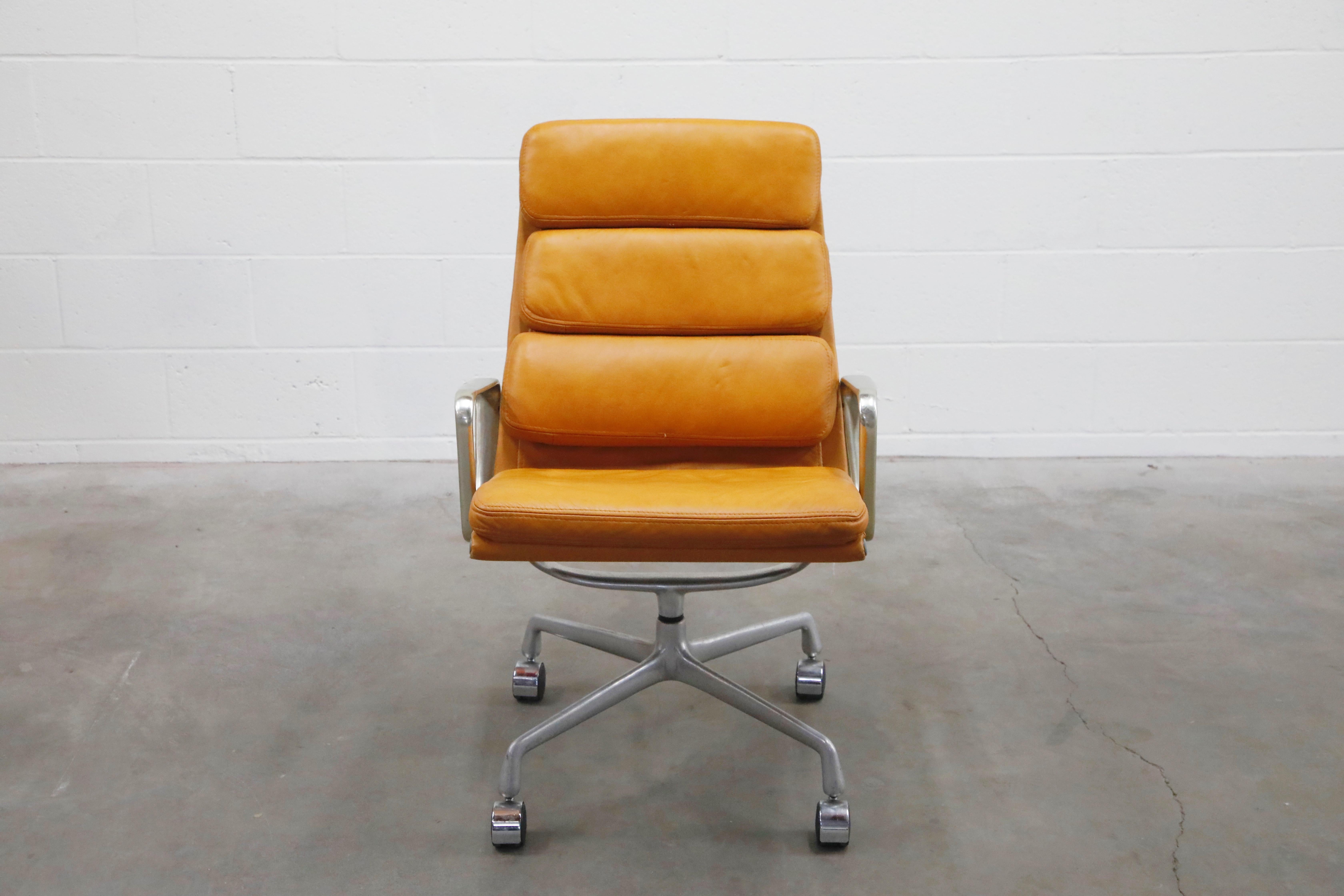 Incredible cognac color leather on this pair of early year production Charles and Ray Eames for Herman Miller high-back Executive Soft Pad swivel chairs. The light aging to the leather provides a soft patina that is so attractive and adds greater