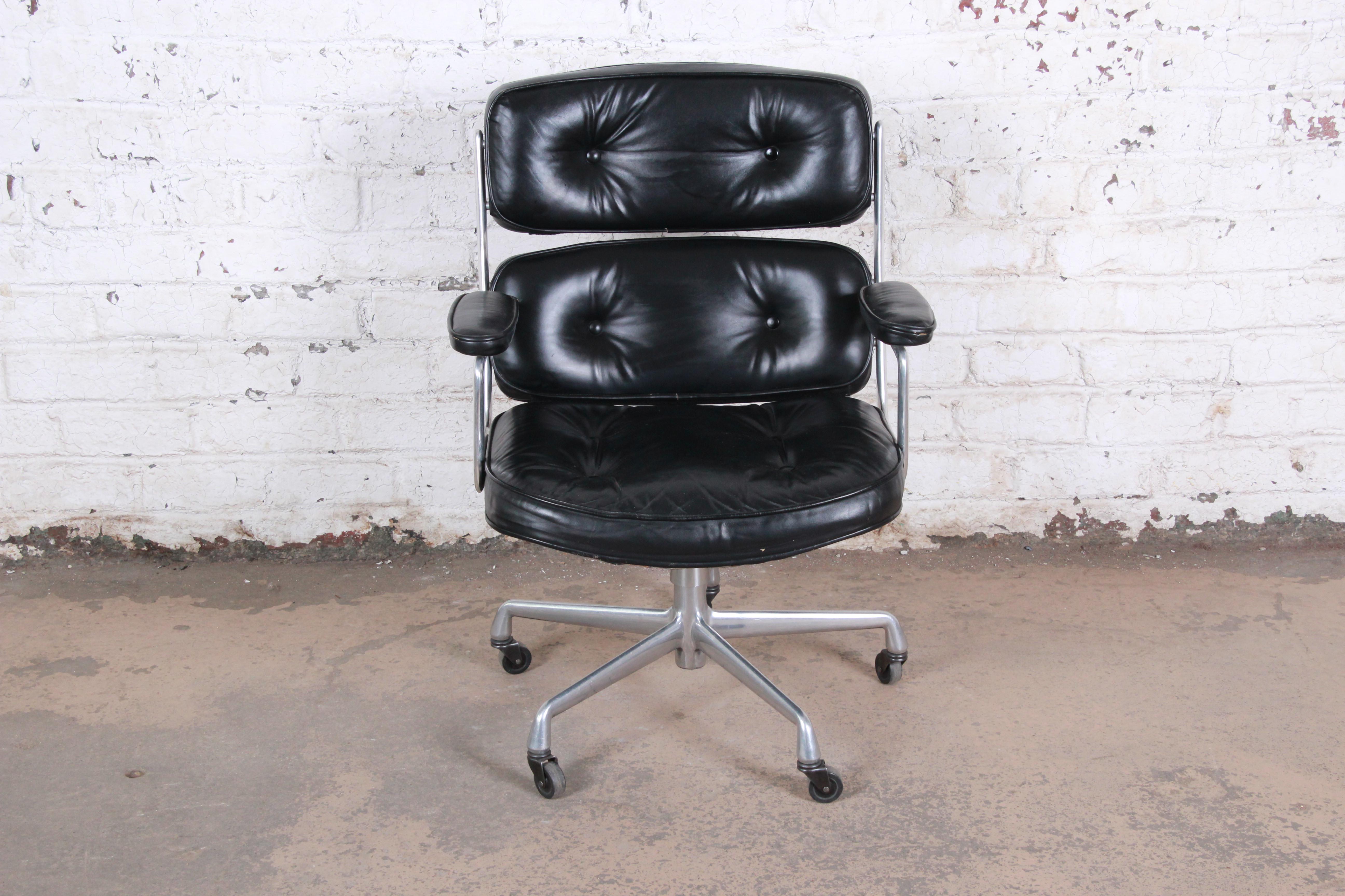 An iconic and timeless piece of American history, Charles Eames designed this chair for the Time Life building in New York City in 1959. Combining style and comfort, this chair features original tufted black leather upholstery, with padded armrests