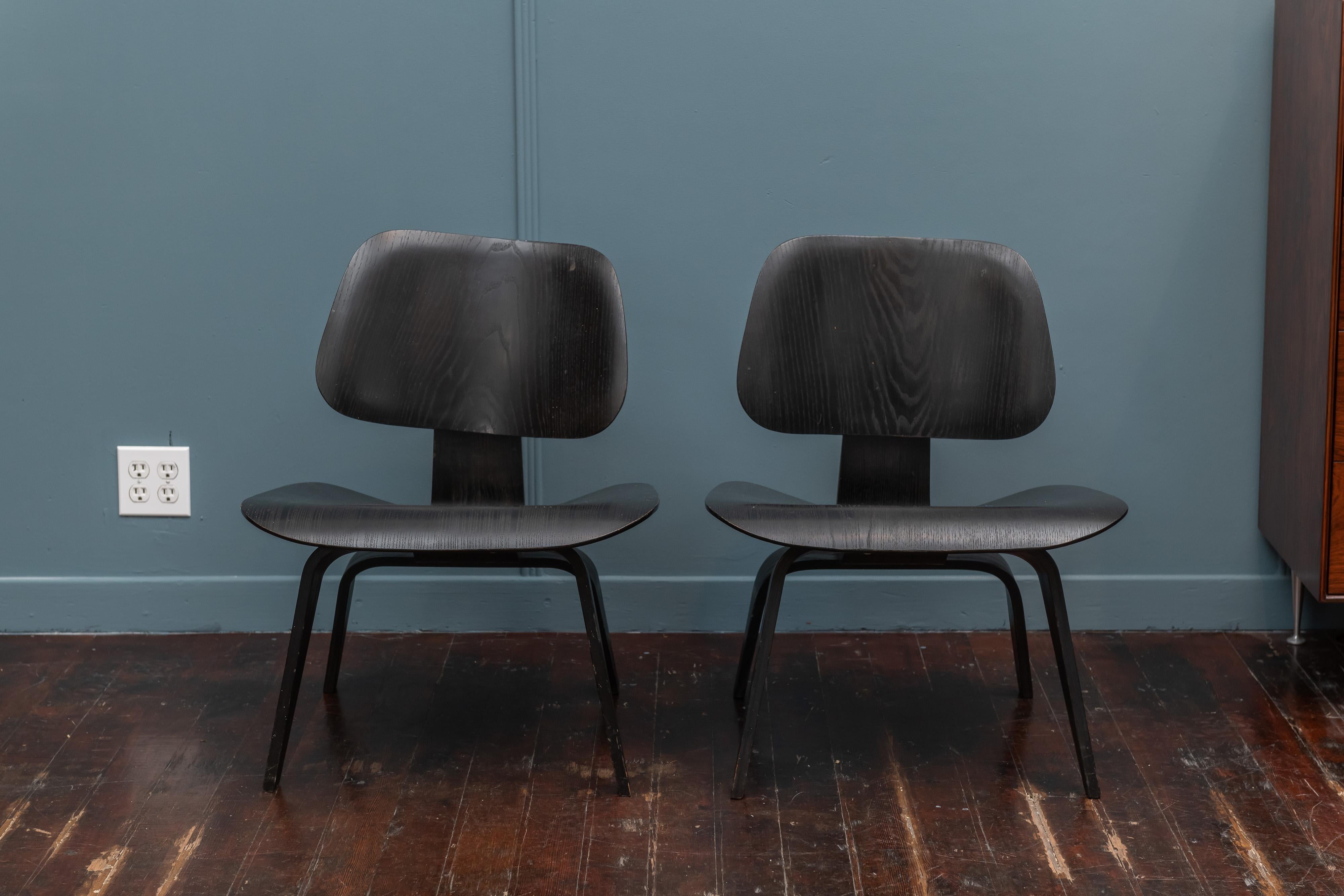Seltenes Paar frühe Produktion (5 x 2 x 5 Schraubbefestigungen) Charles Eames Design LCW (Lounge Chair Holz). Originale schwarze Analine-Lackierung in sehr gutem Originalzustand.
Eine hintere Stoßdämpferhalterung ist getrennt, aber stabil und