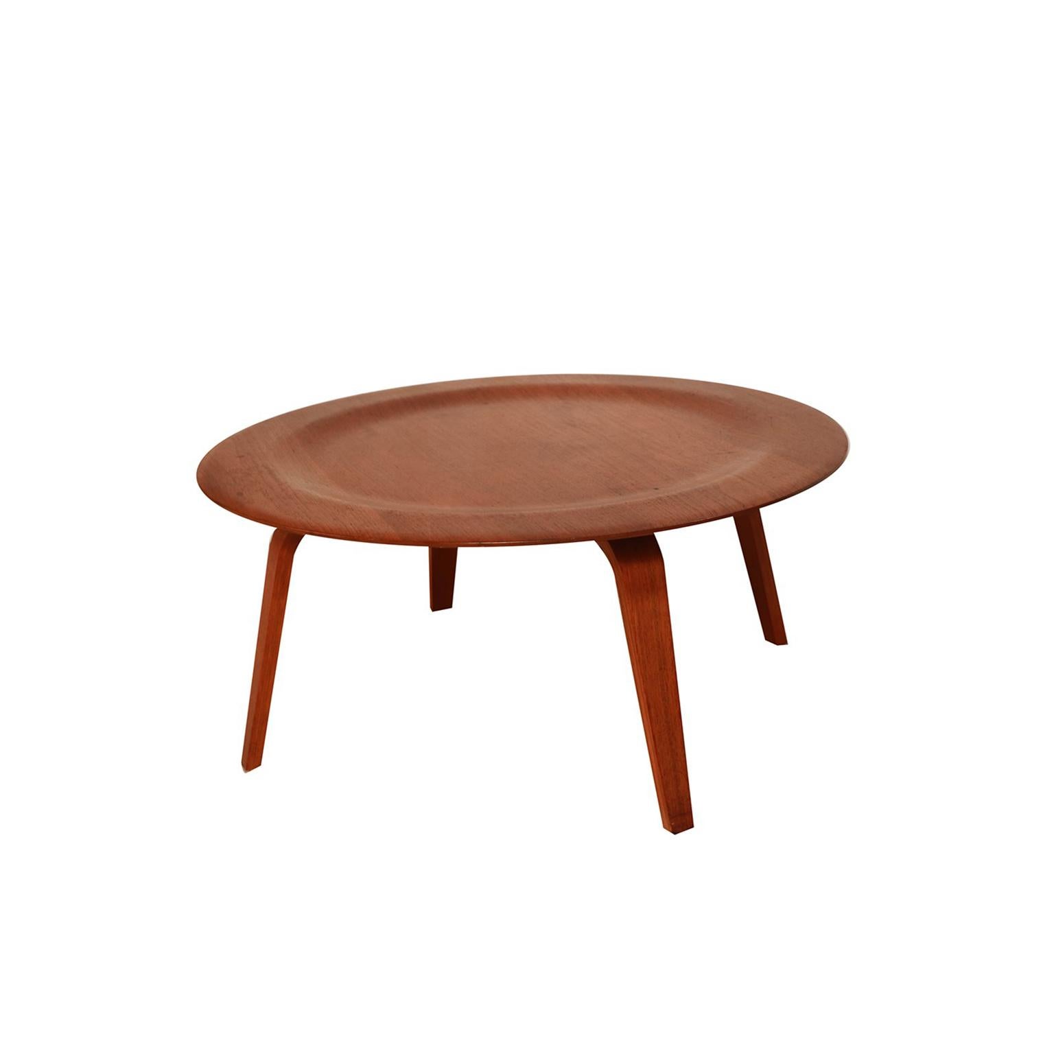 Iconic molded plywood CTW coffee table designed by Charles Eames for Herman Miller. Features a beautifully grained circular molded walnut plywood top with a wide raised edge and walnut bentwood legs all with the original finish. This Classic example