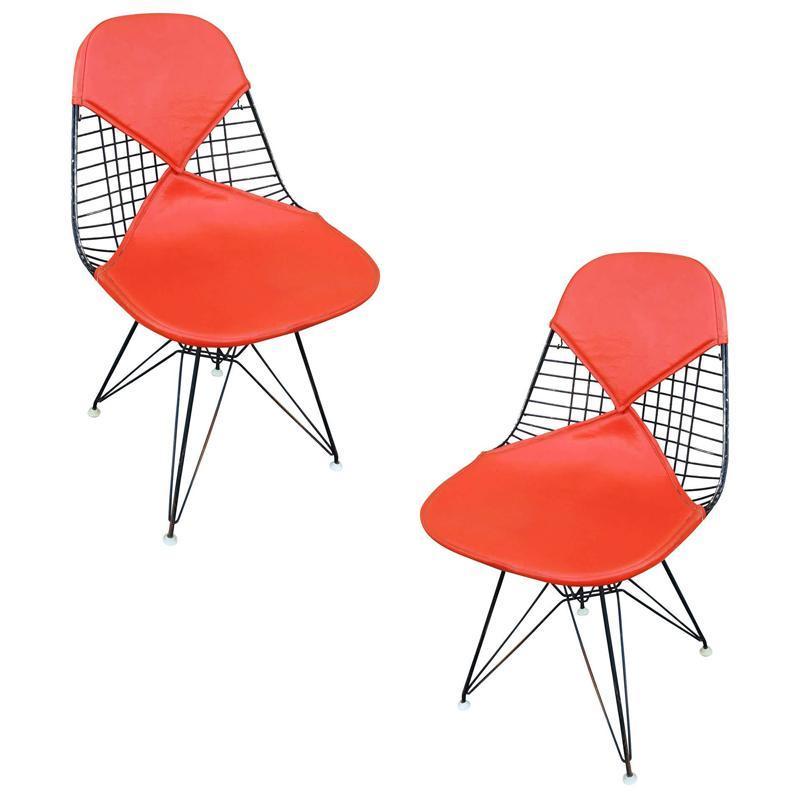 Set of four original Charles Eames designed DKR chair with 2 orange and 2 white bikini pads on a black Eiffel base, made by Herman Miller. The wireframe has been restored with an all original seat cover.