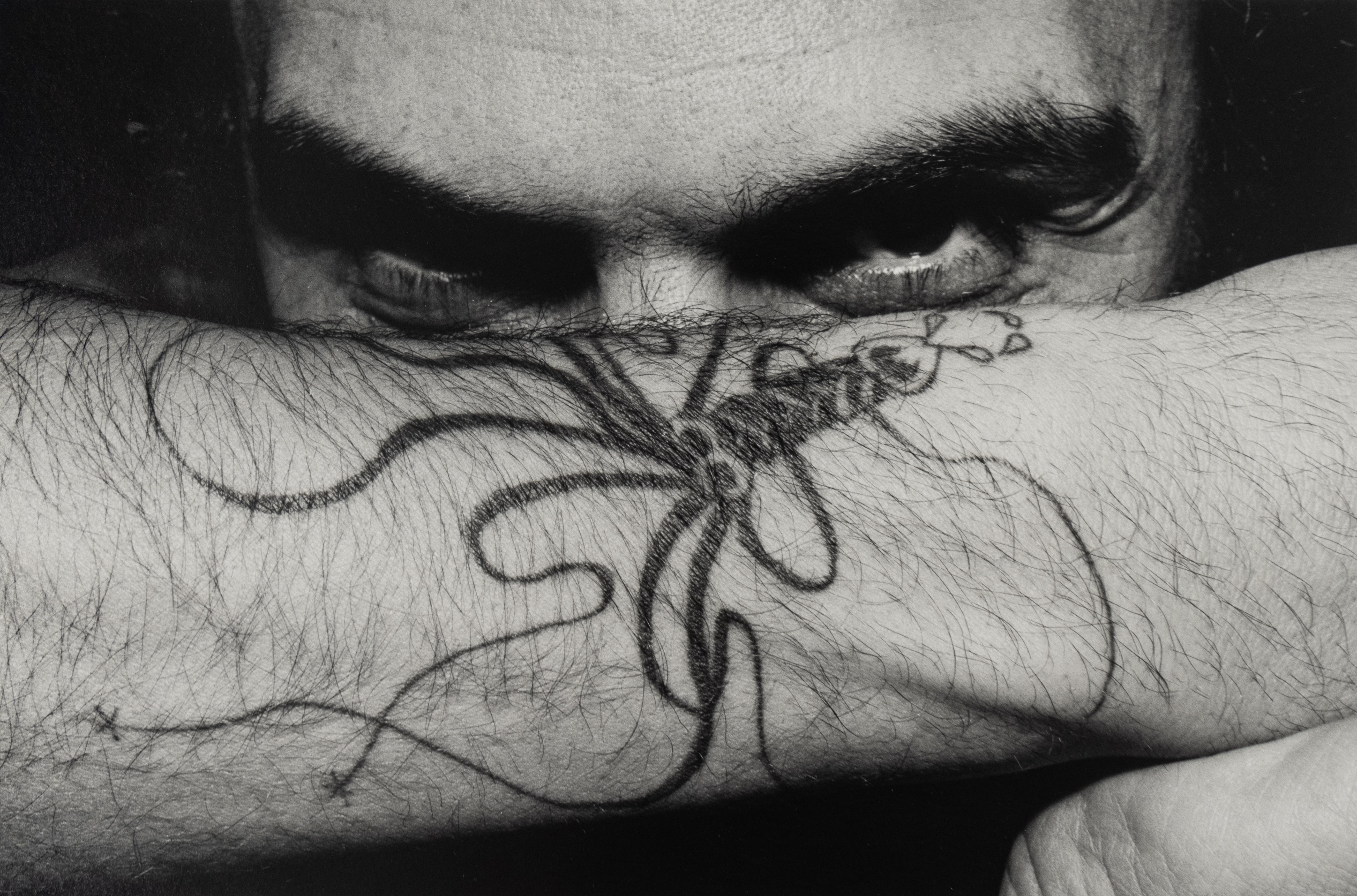 "Squid Tattoo", portrait photographique en noir et blanc et en gros plan de Charles Gatewood représentant un homme avec un tampon du Studio à l'encre noire, verso.

Tirage gélatino-argentique

11 x 14 pouces, feuille
6.5 x 10 pouces, image

Charles