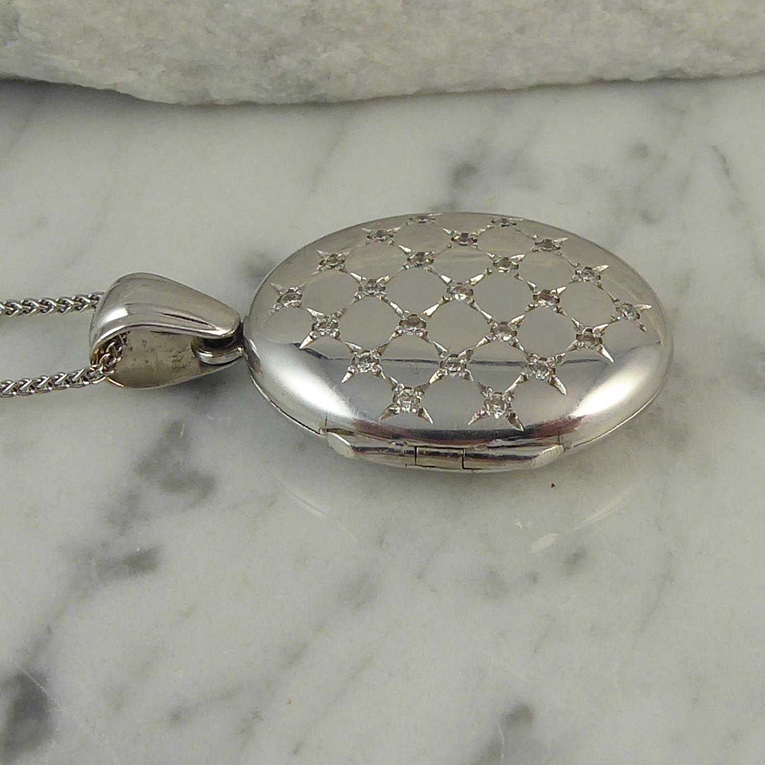 Hand made in the UK by renowned manufacturer, Charles Green, who were established in 1824 and are now into their sixth generation.  The locket has been created in 18ct white gold and features to the front a quilted pattern studded with a diamond at