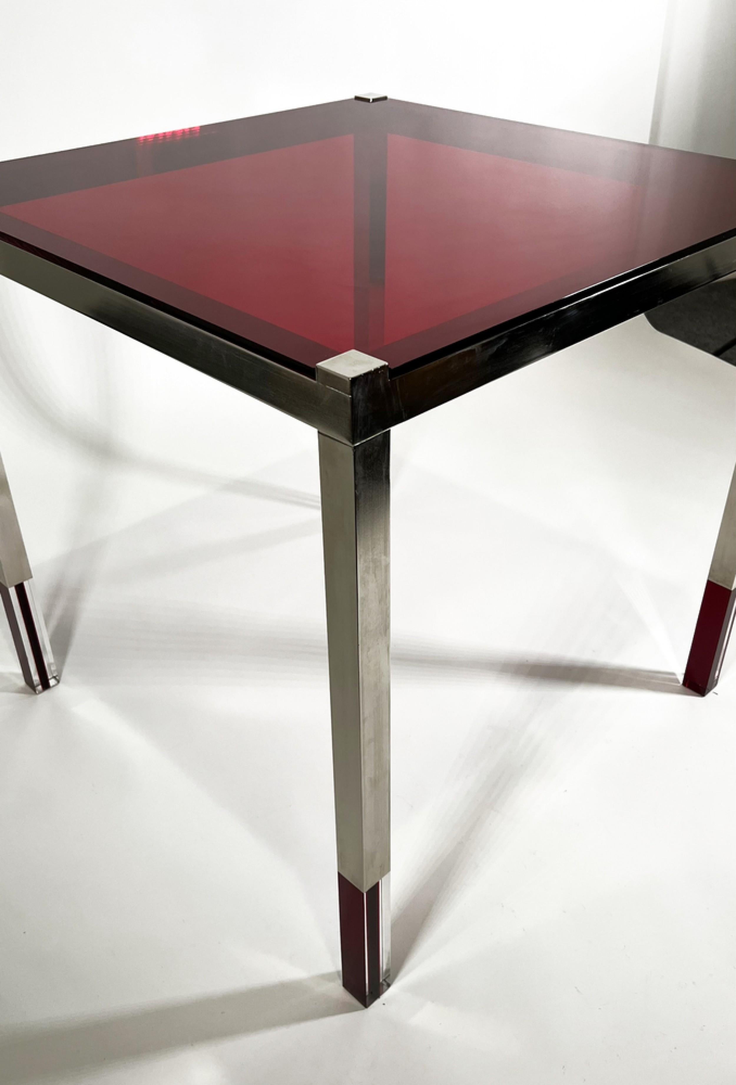 Midcentury American Modern game / end / side table with a polished nickel frame with a red lucite top and clear and red lucite sections in the table\'s legs. (Charles Hollis Jones).