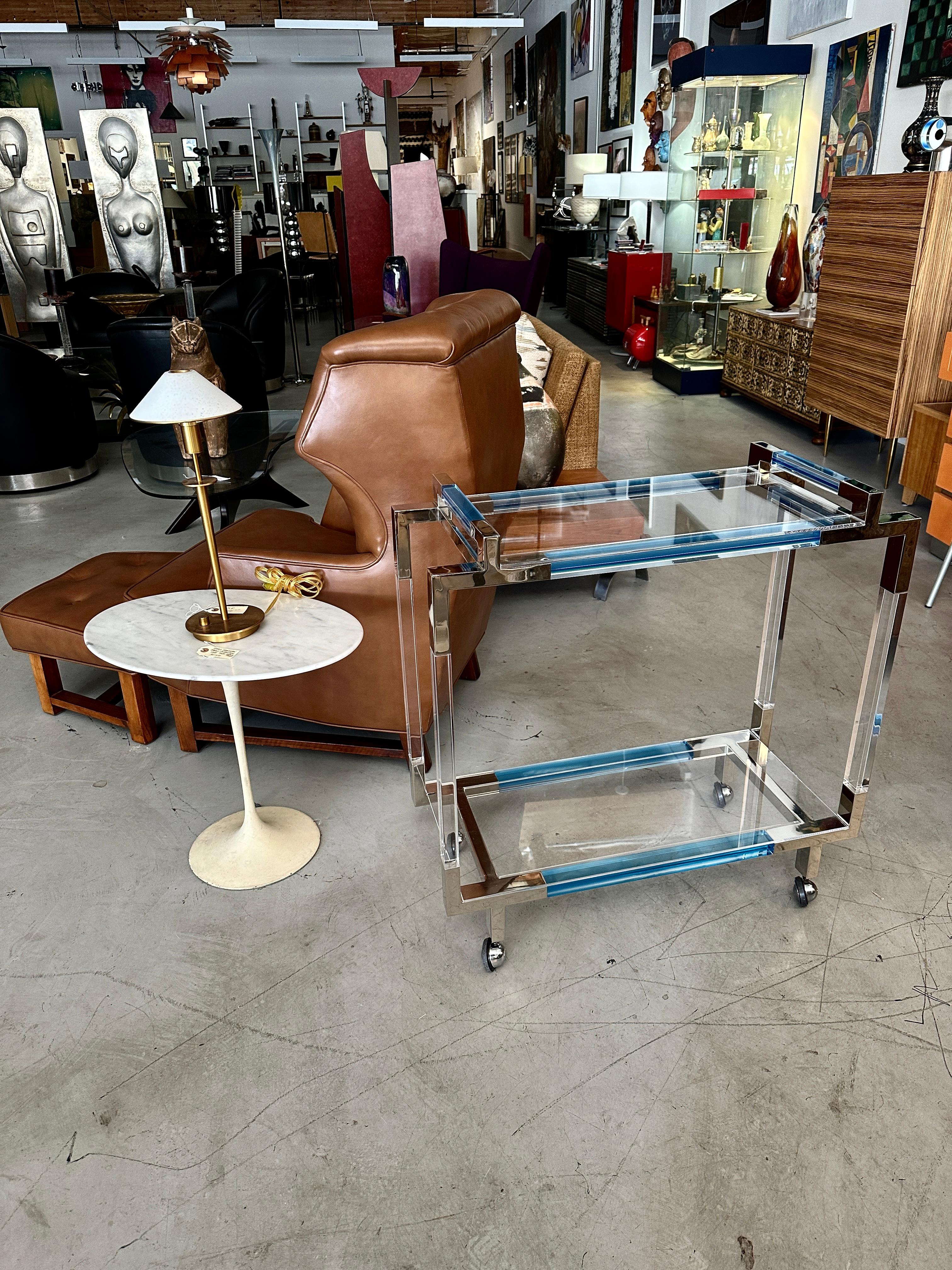 A lovely Charles Hollis Jones bar cart with Aqua colored accent sides and handles. On rubber trimmed castors for easy movement. The top and bottom shelf are lucite. The trim is polished nickel. There are drop in lucite pieces on the top and bottom