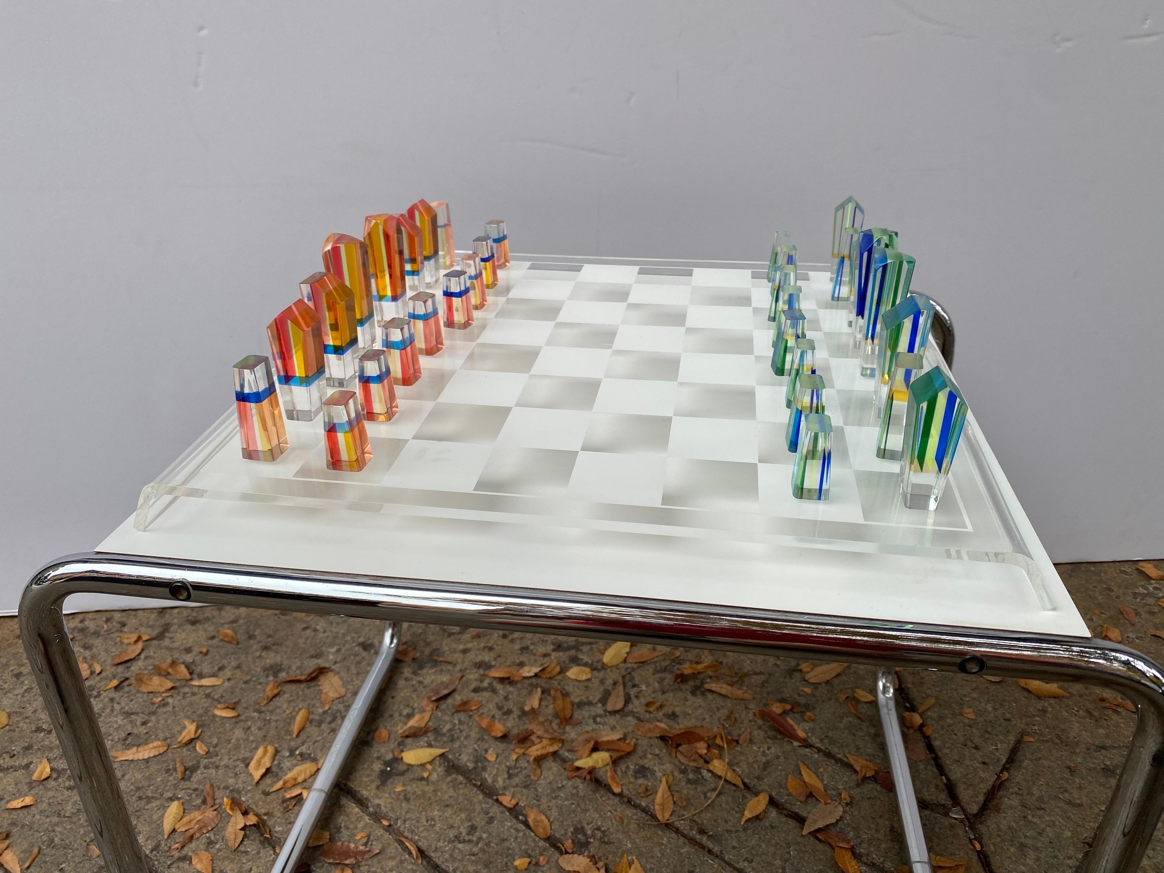 Charles Hollis Jones Lucite chess set and board. Lucite game pieces made of stacked colored lucite. One grouping is in shades of oranges and reds and other half are in blue and greens. Pieces are in very nice shape with no chips or cracks. Probably